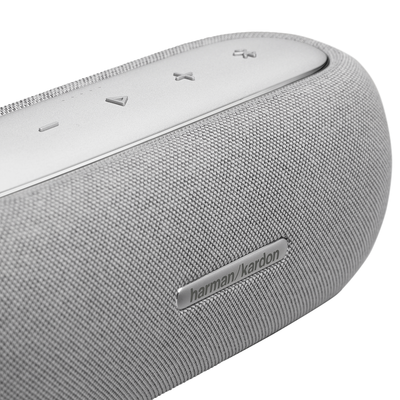 Primer plano de un altavoz gris con el logotipo de harman/kardon y botones en la parte superior.