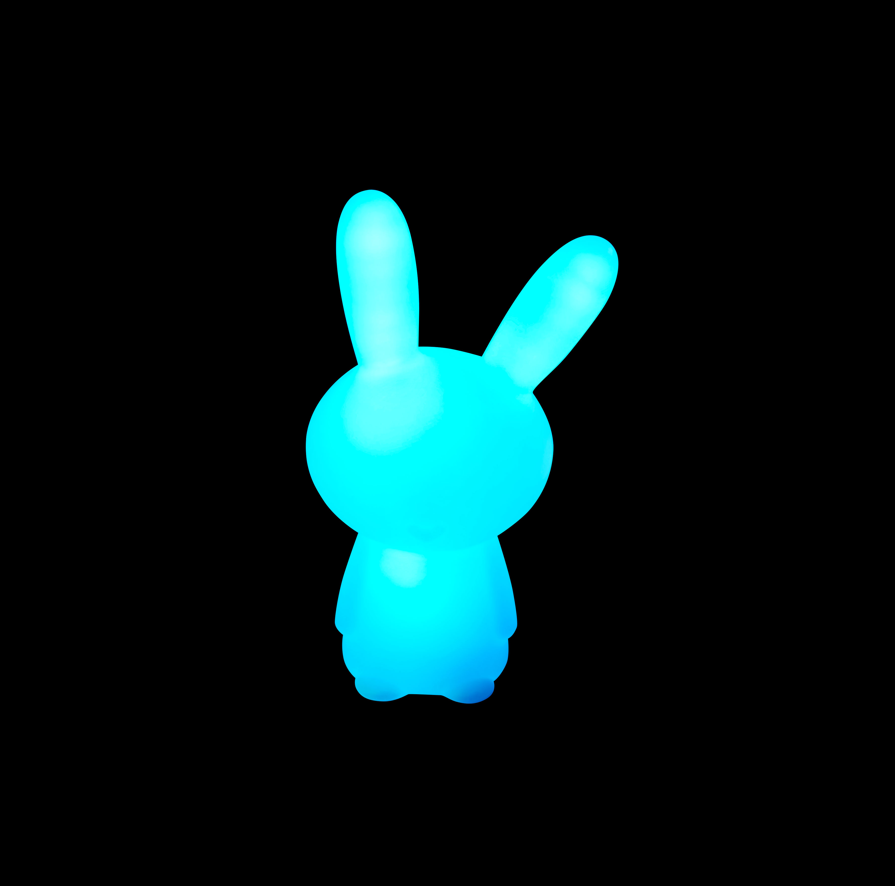 Ein leuchtendes blaues Kaninchen-Nachtlicht vor schwarzem Hintergrund.