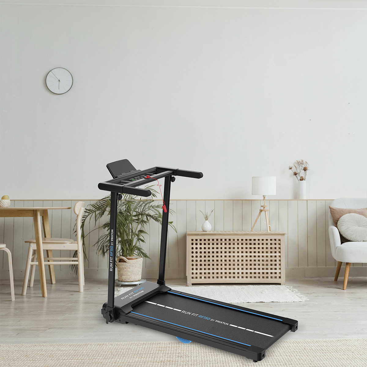 Bieżnia w pokoju. Pokój ma białą ścianę, stół, roślinę i sofę.