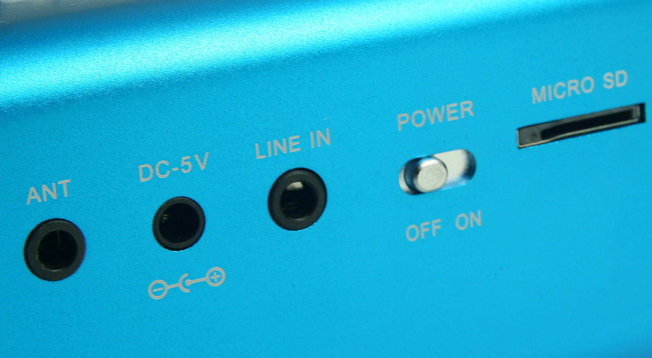 Zbliżenie niebieskiego urządzenia z portami oznaczonymi ANT, DC-5V, LINE IN, Power i Micro SD.