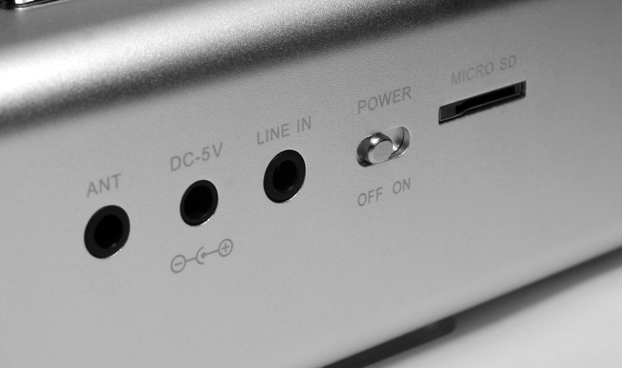 Zbliżenie tylnego panelu urządzenia elektronicznego. Zawiera porty i przełącznik zasilania.