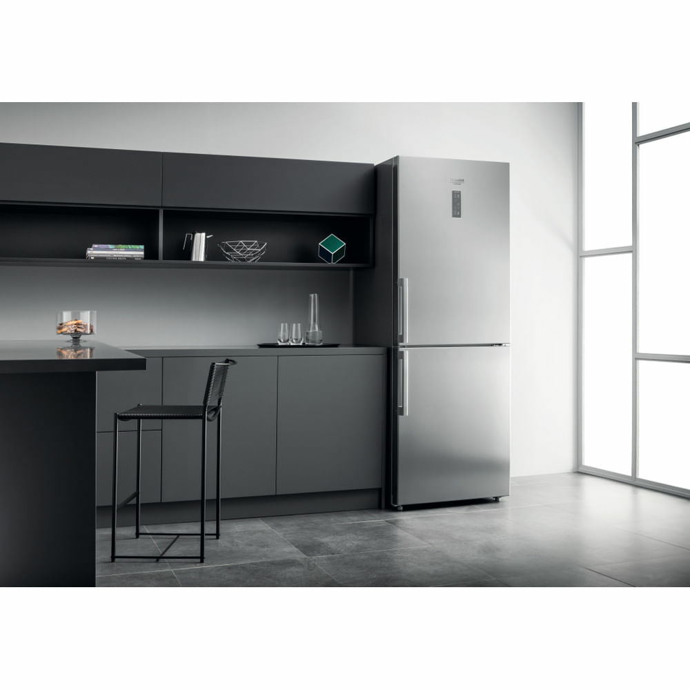 Una cucina moderna con un frigorifero in acciaio inossidabile, un piano di lavoro e uno sgabello da bar.