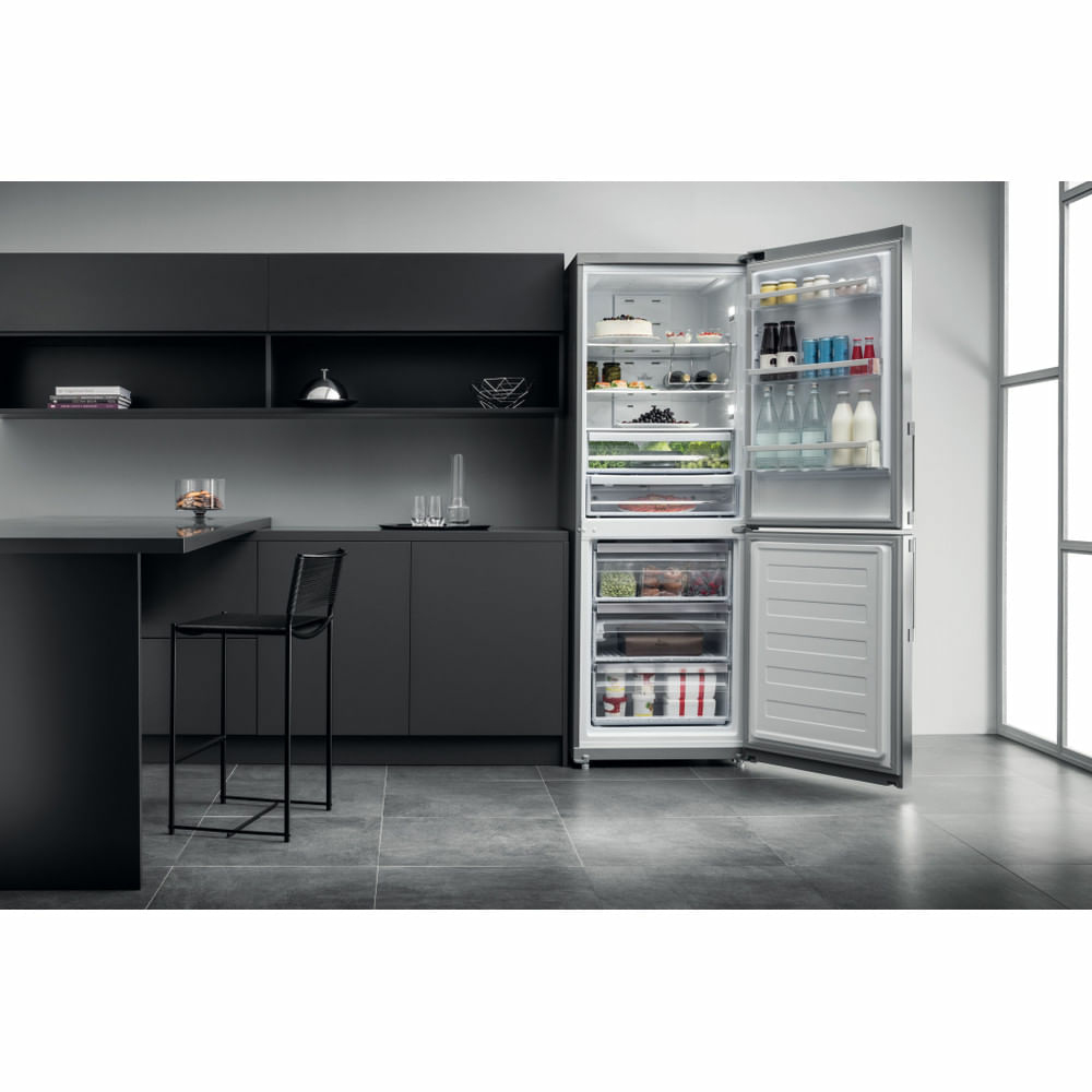 Interno cucina con frigorifero aperto, mostra ripiani con cibi e bevande.