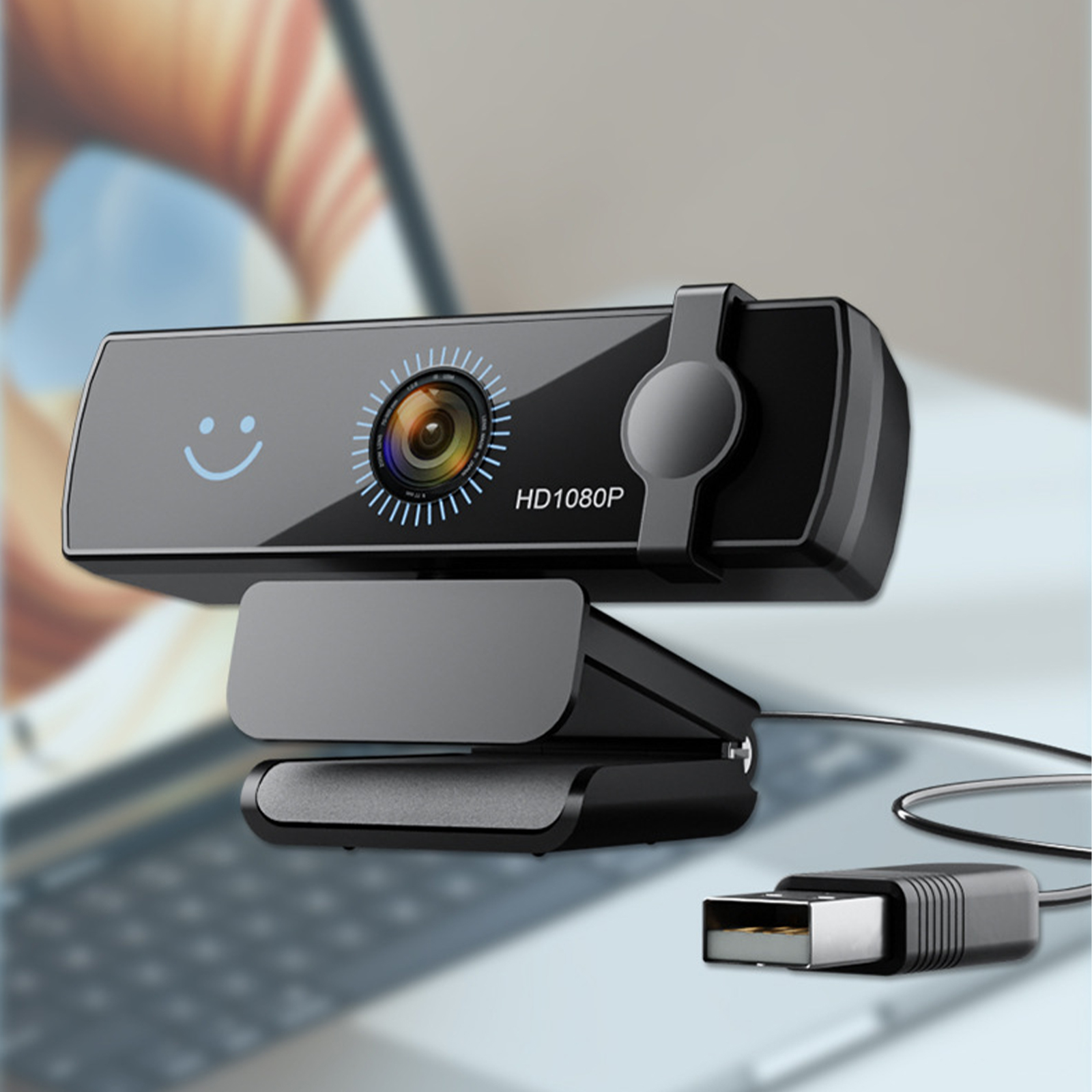 Eine schwarze Webcam mit einem Smiley-Gesicht. Sie ist per USB-Kabel mit einem Laptop verbunden.