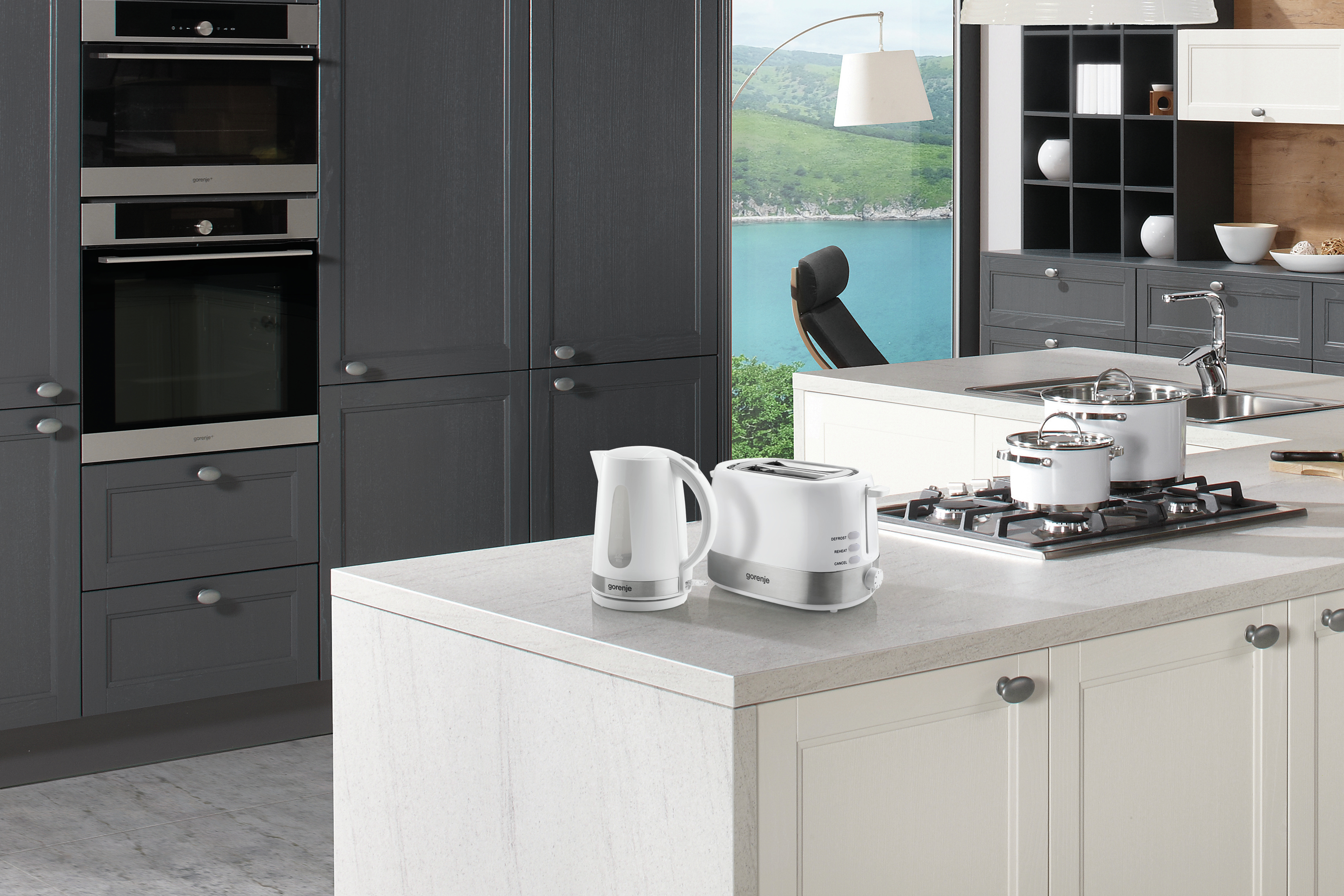 Cucina moderna con isola, elettrodomestici e vista sull'oceano dalla finestra.