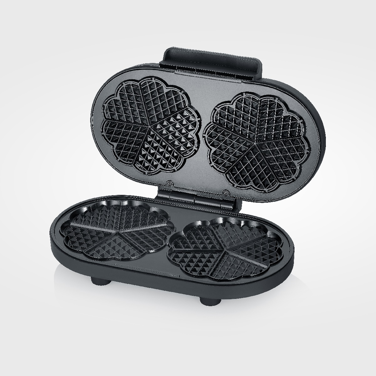 Schwarzer Waffeleisen offen, zeigt zwei herzförmige Backflächen.
