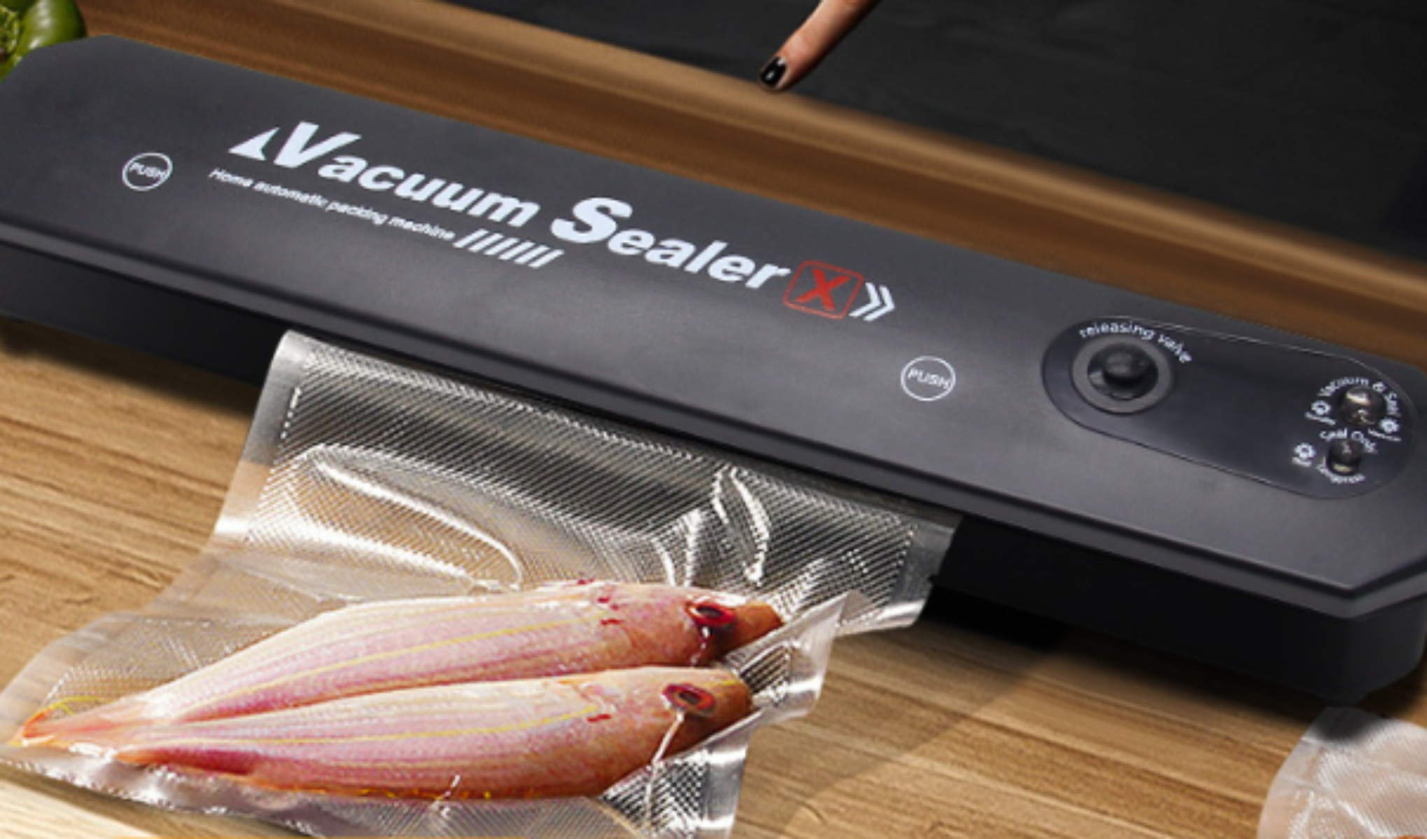 Vakuumiergerät verschließt Beutel mit zwei rohen Fischen. Schwarzes Gerät mit Knöpfen.