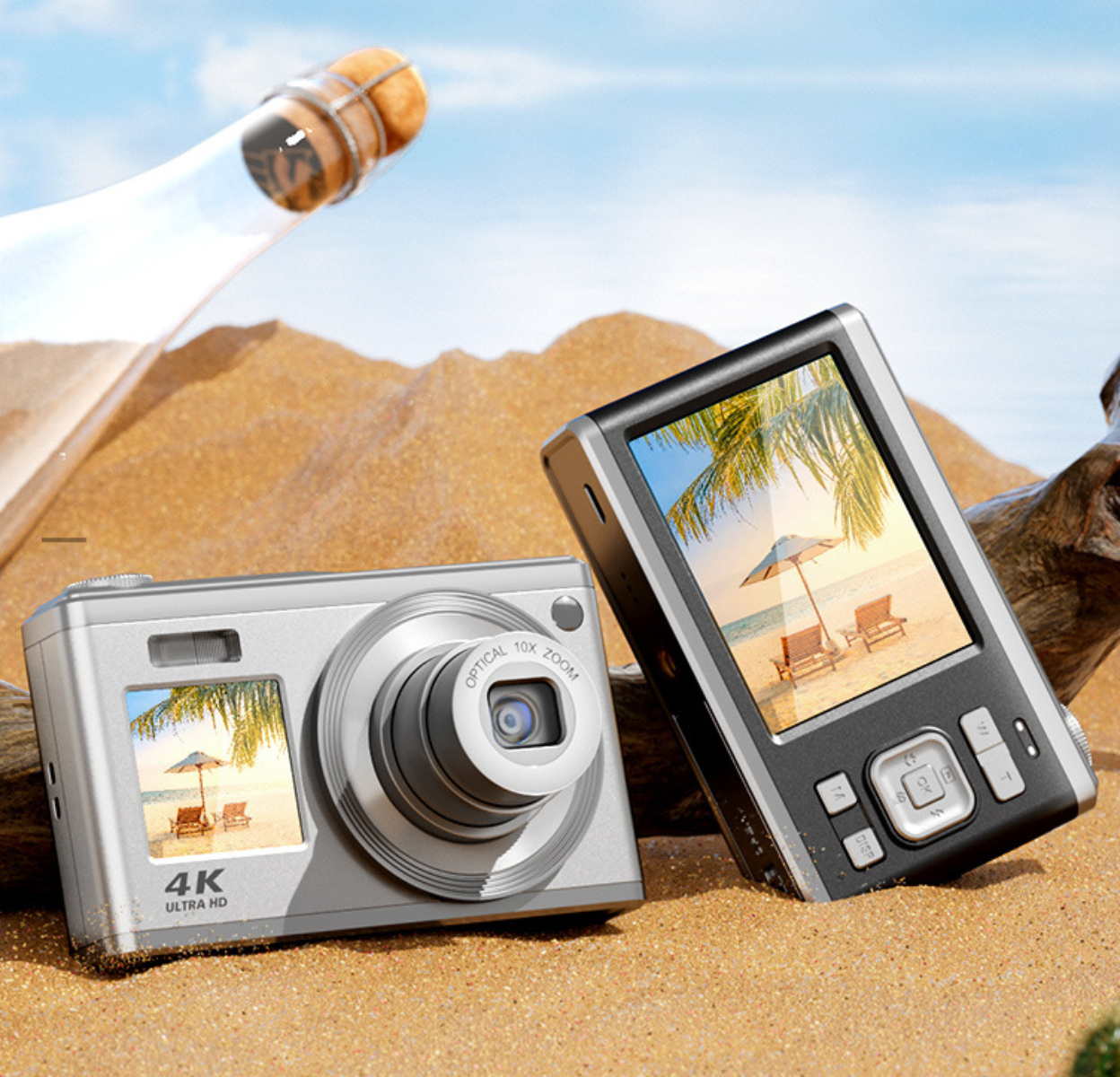 Zwei Digitalkameras auf Sand, eine zeigt eine Strandszene auf ihrem Bildschirm, mit einer Flasche.