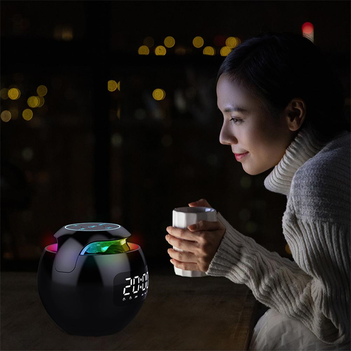 Frau bei Nacht betrachtet Smart Speaker mit leuchtendem Display, hält Tasse.
