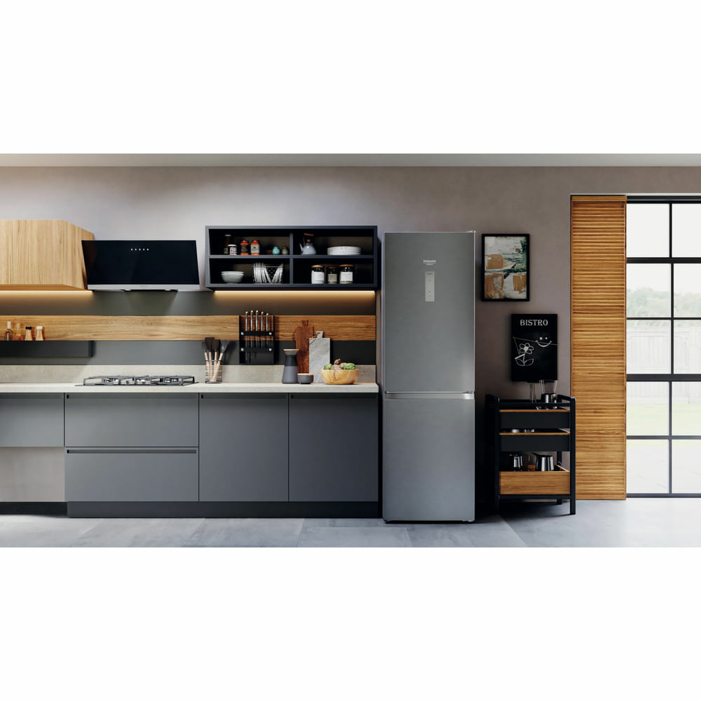 Cucina moderna con mobili grigi, frigorifero in acciaio inossidabile e cappa nera.