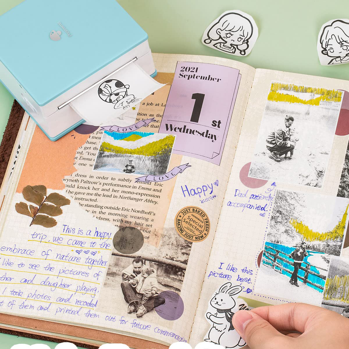 Ein Journal mit gedruckten Fotos, Aufklebern und handschriftlichen Notizen, ein blauer Mini-Drucker steht daneben.