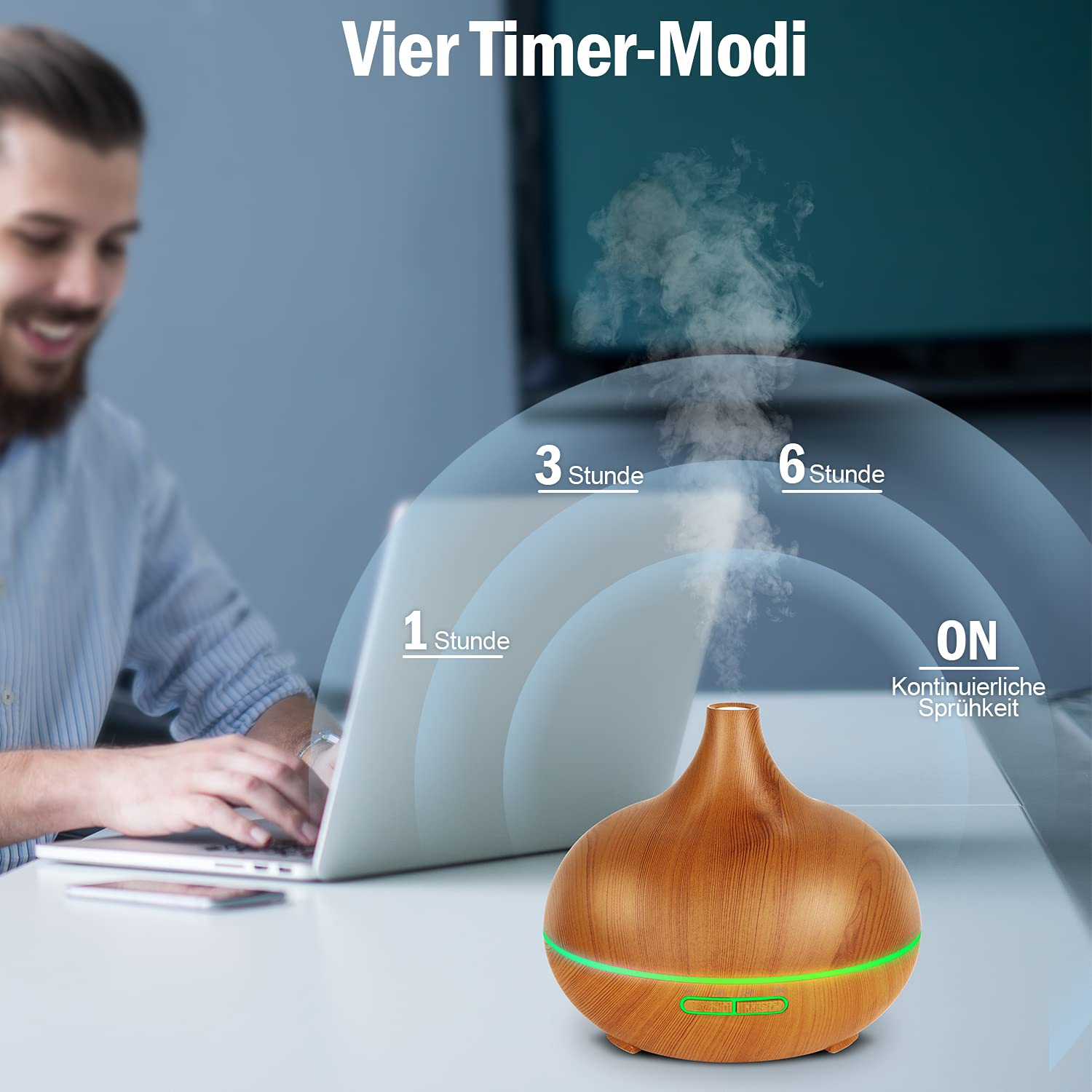 Aromadiffusor mit Holzfinish, grünem Licht und Dampf. Mann arbeitet im Hintergrund an Laptop. Timer-Optionen: ON, 1, 3, 6 Stunden.
