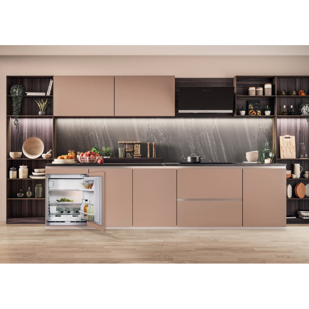 Cucina moderna con frigorifero aperto, armadi e pavimento in legno; cibo visibile.