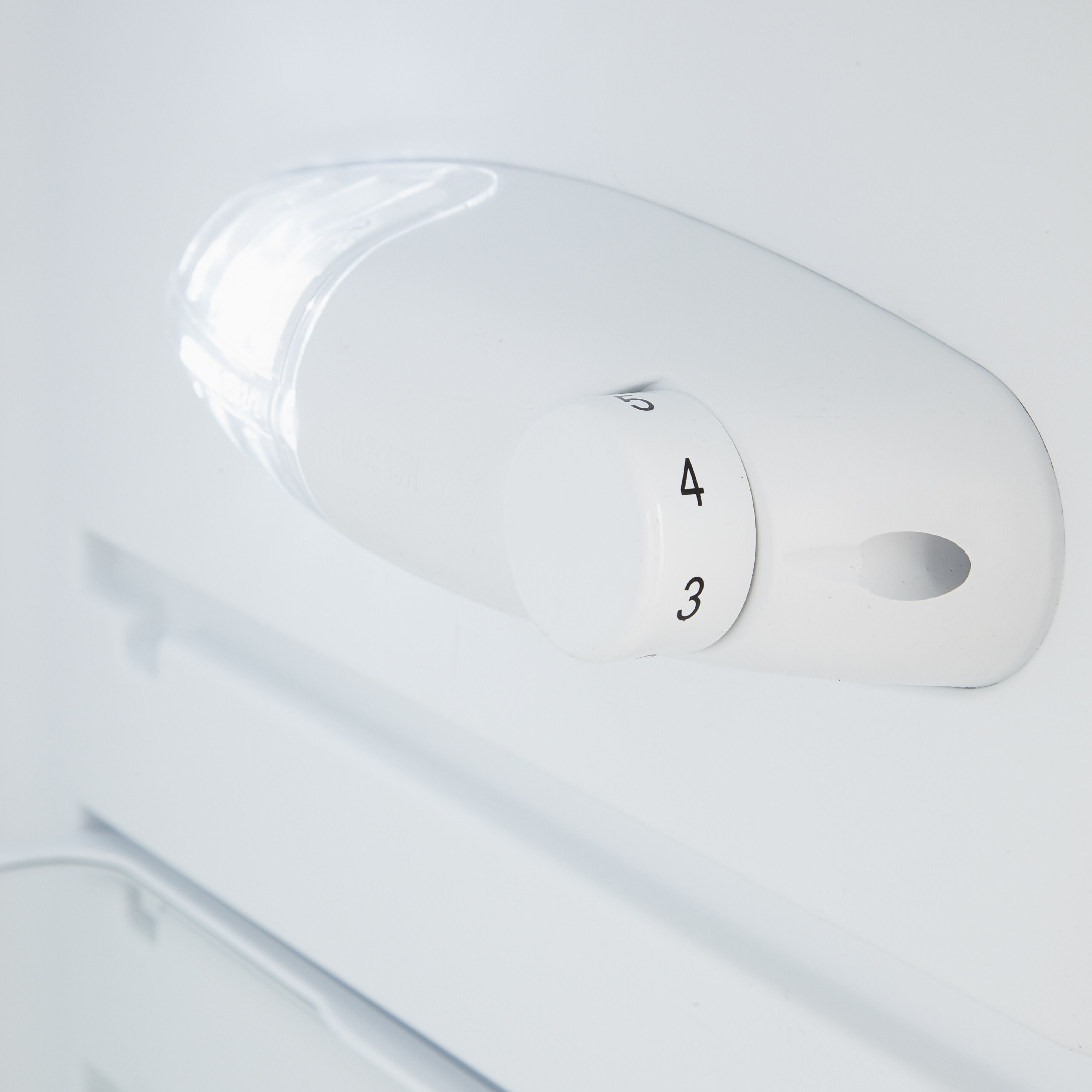 A white refrigerator interior with a temperature control dial set to 4.