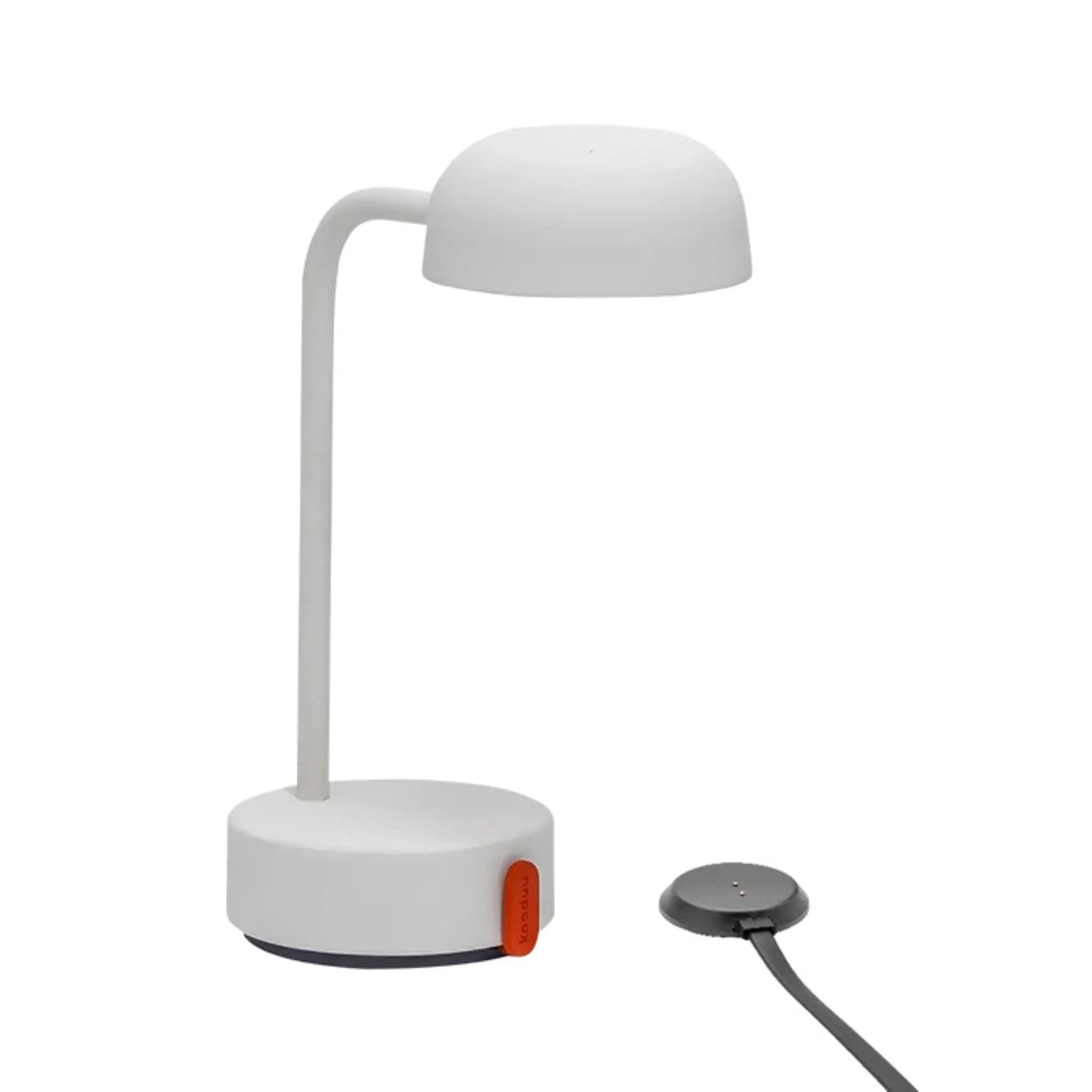 Weiße Schreibtischlampe mit gebogenem Arm und rundem Sockel und schwarzem Ladepad auf weißem Hintergrund.