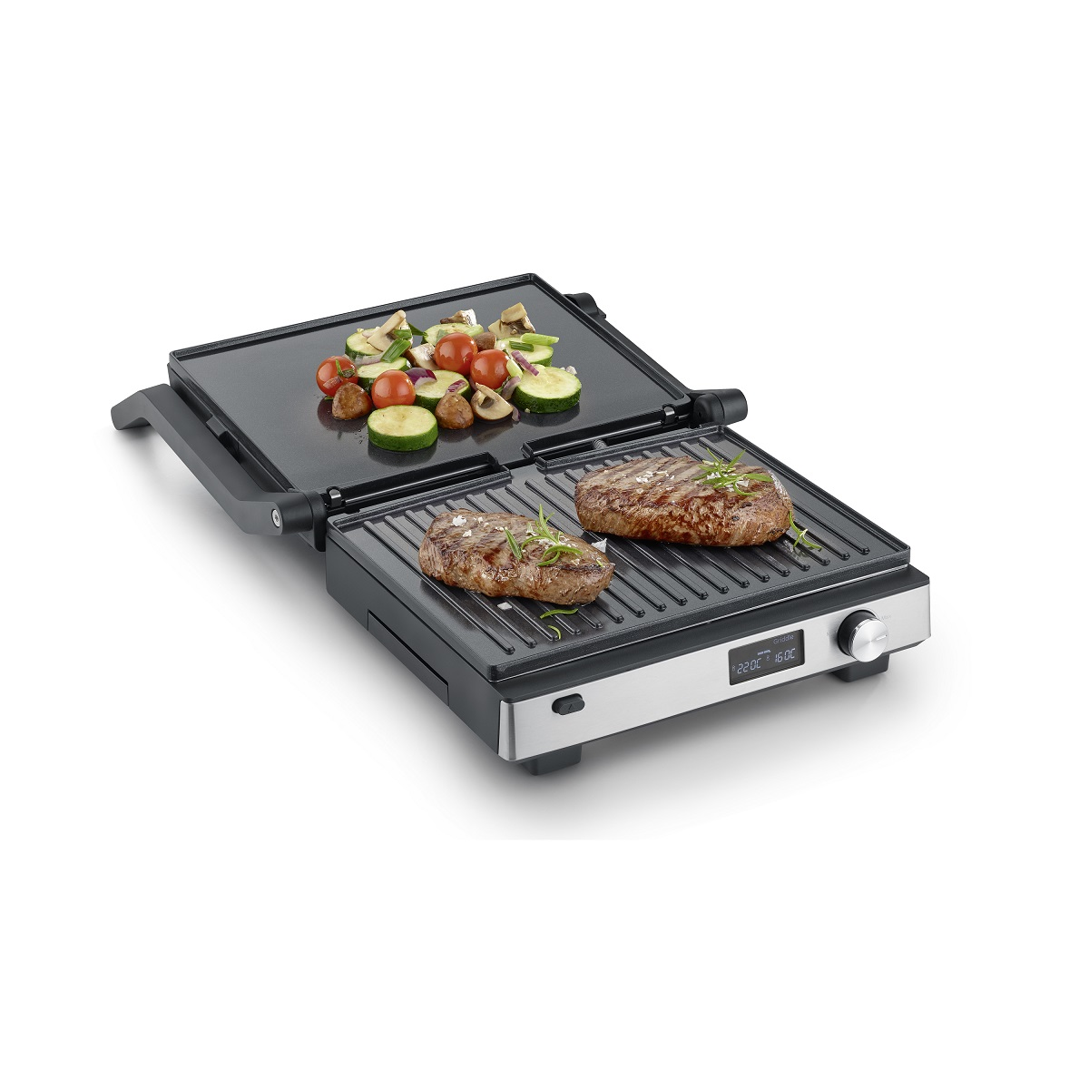 Elektrischer Grill mit gegrilltem Gemüse und Steaks; zwei offene Kochflächen, schwarz und silber.