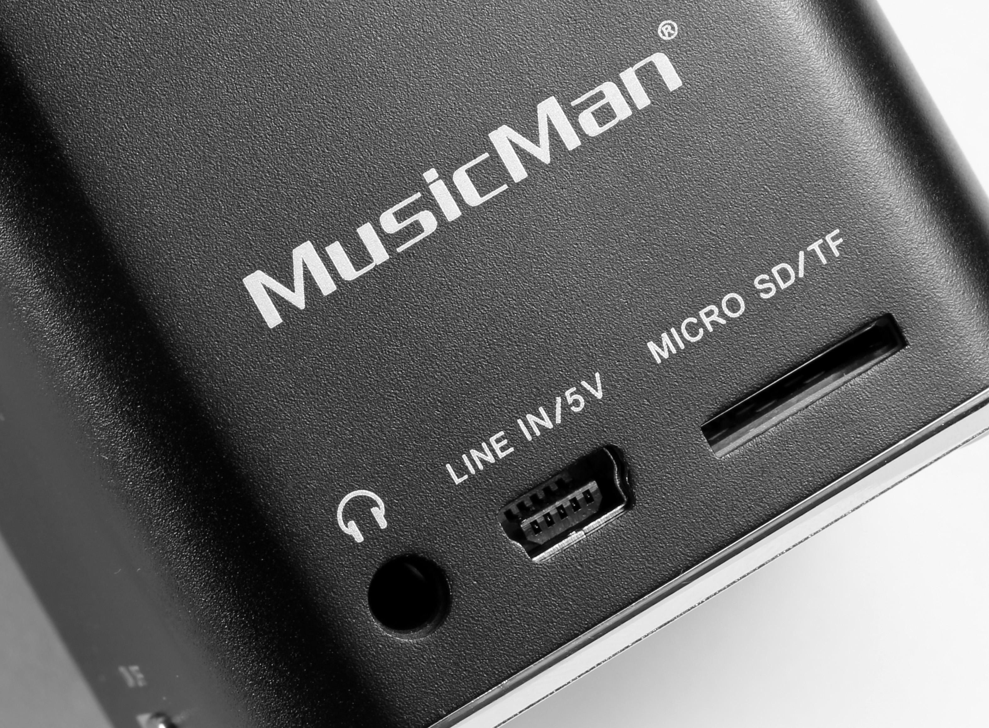 Nahaufnahme eines schwarzen Lautsprechers mit Anschlüssen für Kopfhörer und Micro-SD-Karte.