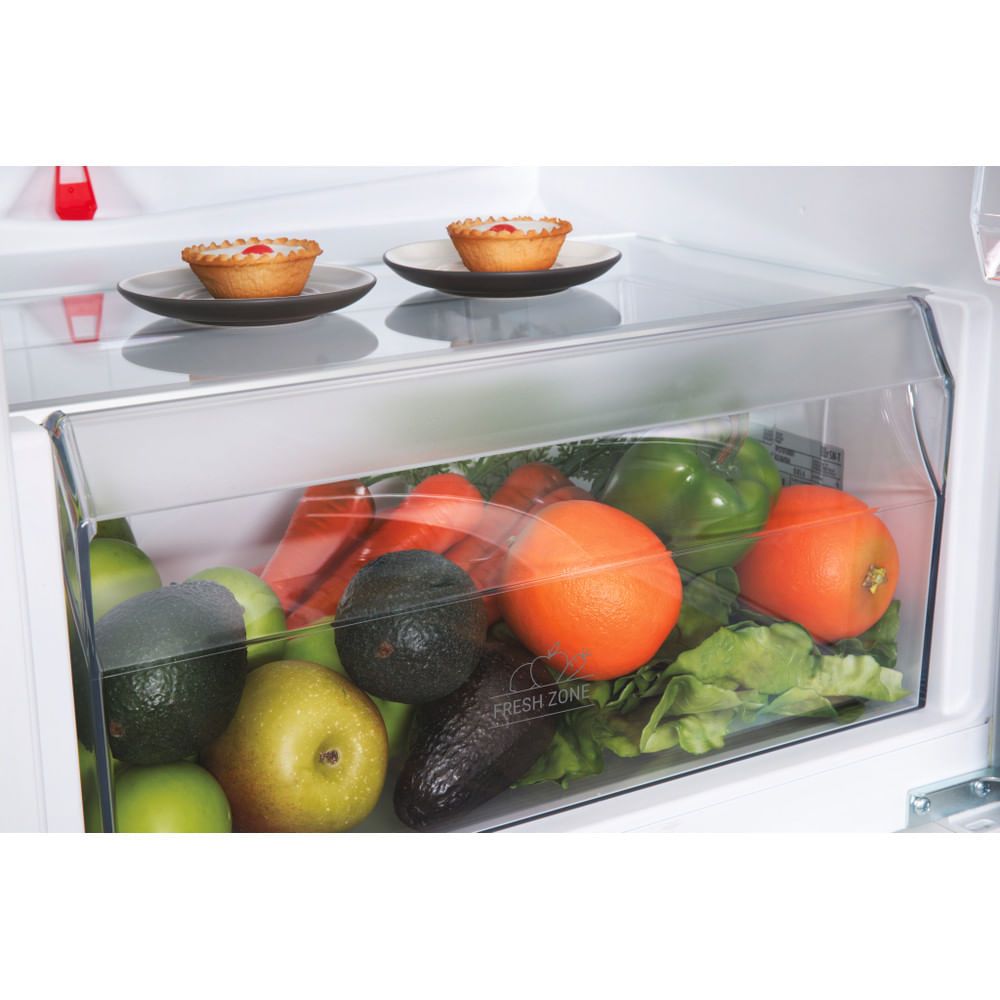 Dentro il cassetto del frigorifero con frutta, verdura e crostate.