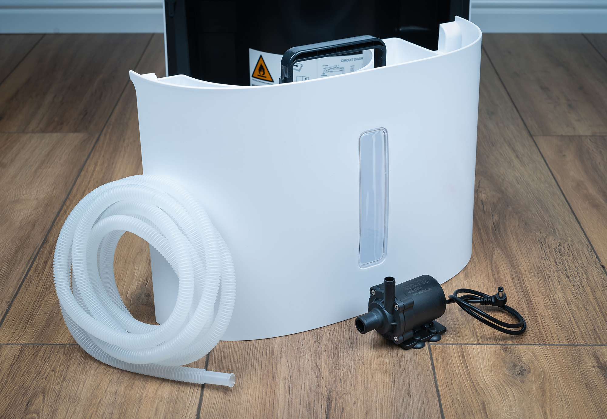 Componenti di un purificatore d'aria bianco con un tubo e una pompa nera.