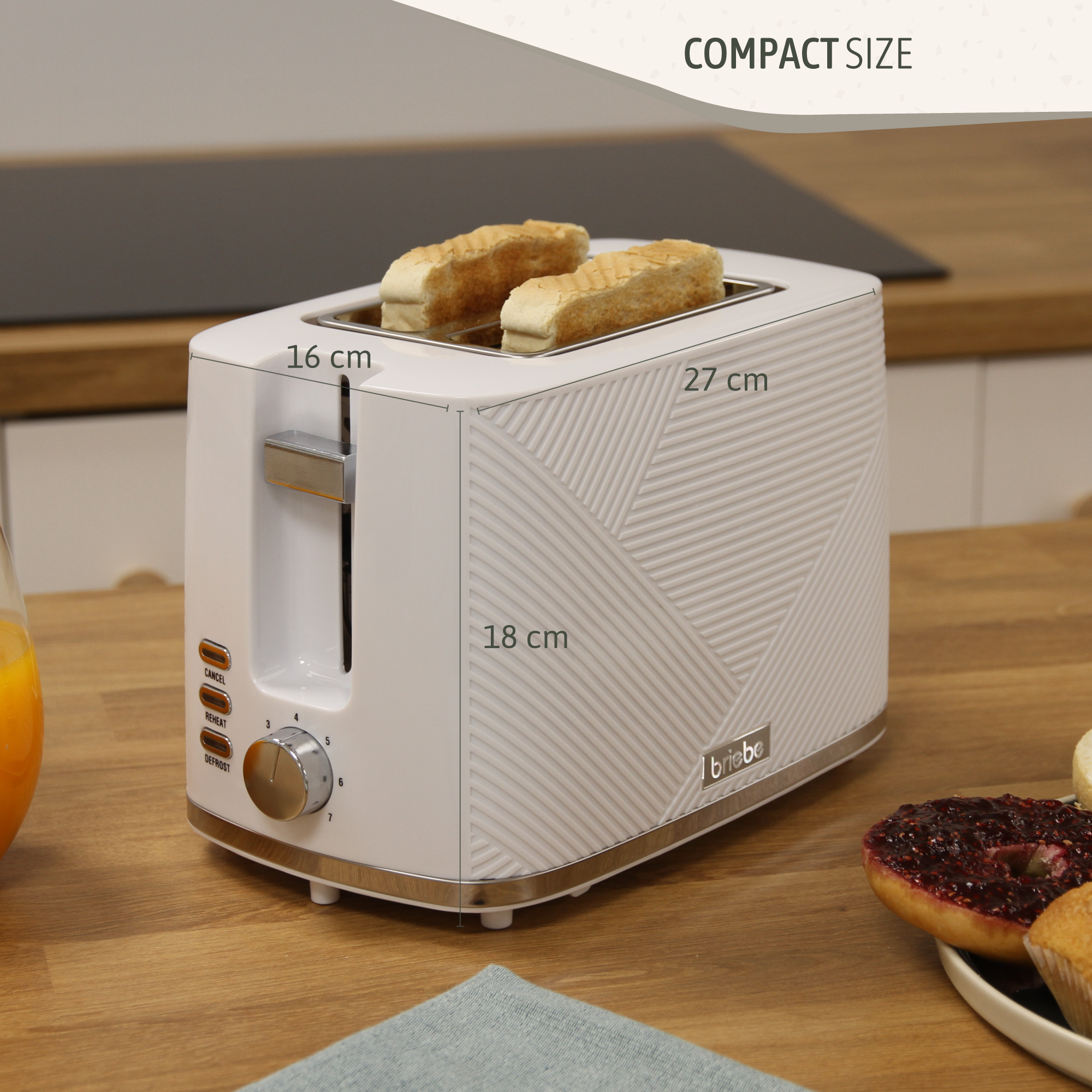 Ein weißer Toaster mit beschrifteten Abmessungen daneben, Brot darin und Küchenhintergrund.