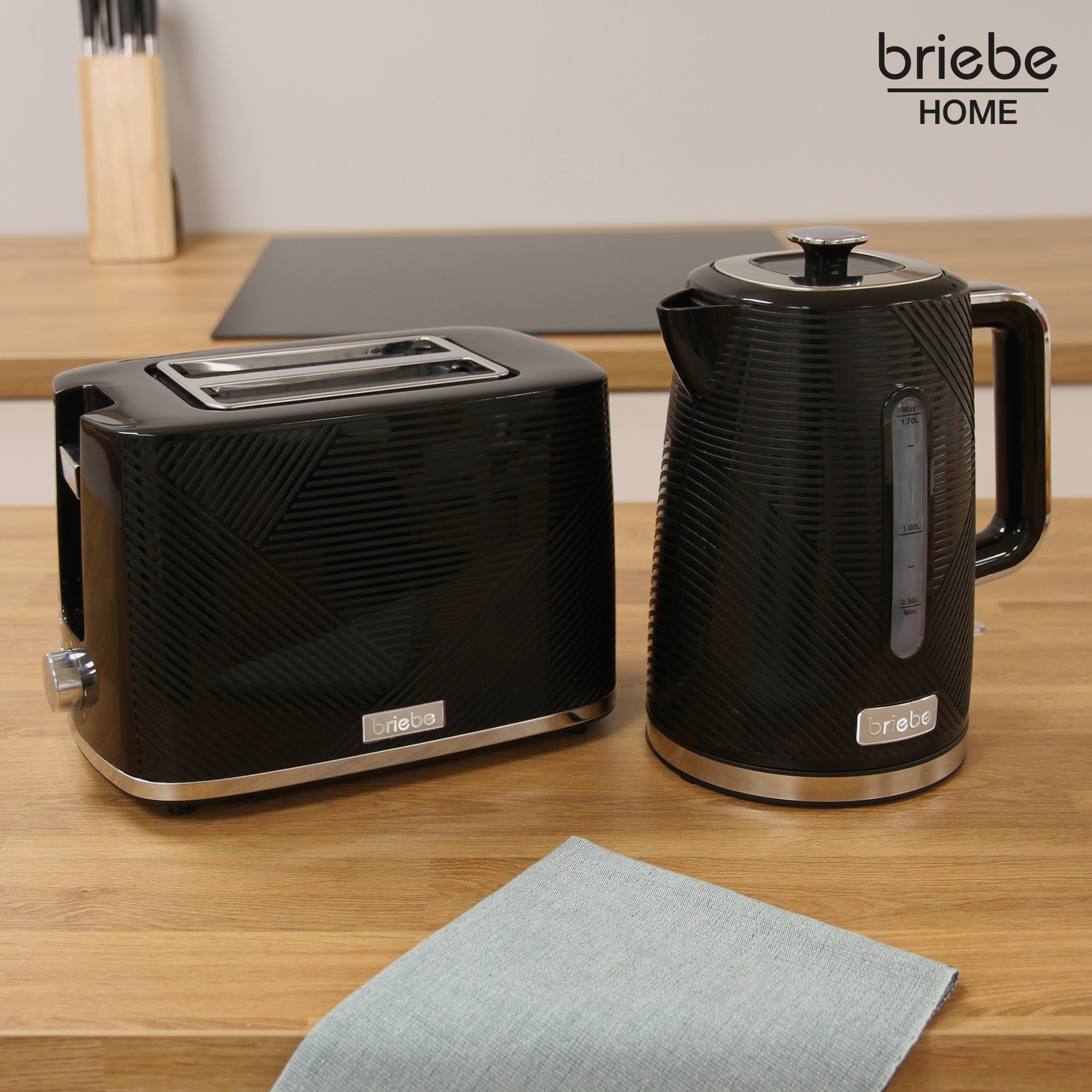 Schwarzes Toaster- und Wasserkocher-Set auf einer Holzoberfläche mit Tuch.