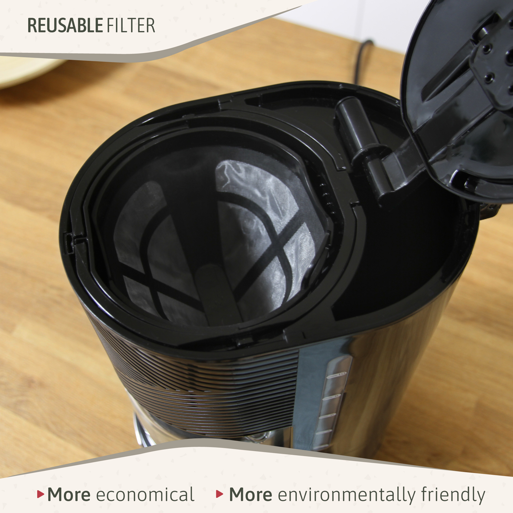 Cafetera negra con filtro reutilizable abierta, mostrando el filtro dentro, en superficie de madera.