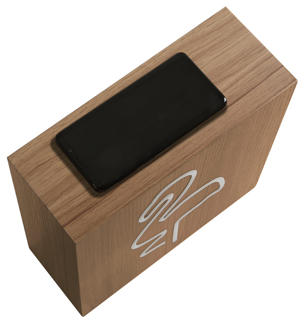 Boîte en bois avec téléphone dessus. L'écran du téléphone est noir. Logo blanc sur la boîte.