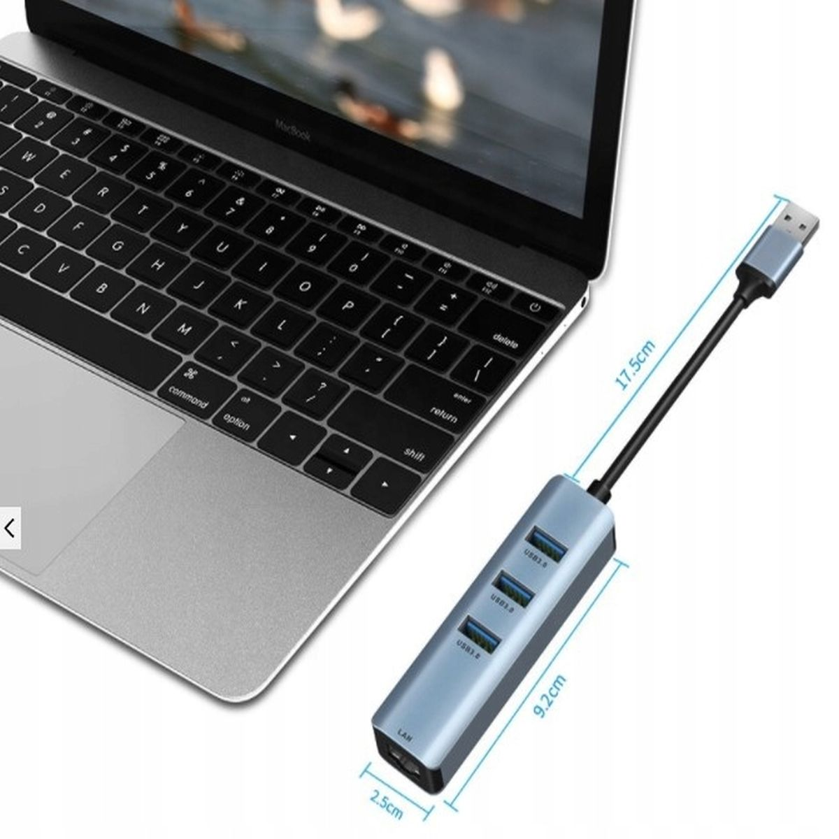 Laptop z podłączonym hubem USB. Hub ma porty USB i port LAN. Kabel prowadzi do złącza USB.