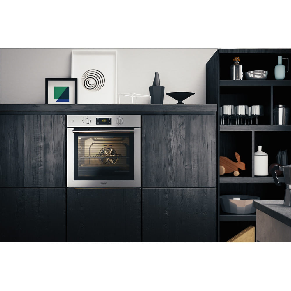 Un forno incassato in mobili neri. Ci sono decorazioni sopra e sui lati.