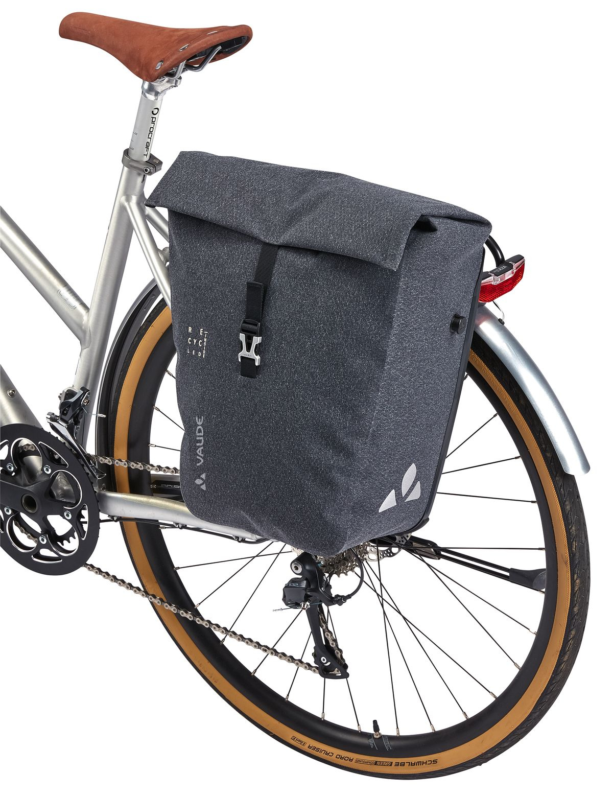 Graue Fahrradtasche am Fahrrad befestigt, mit Vaude-Logo. Das Fahrrad steht vor weißem Hintergrund.