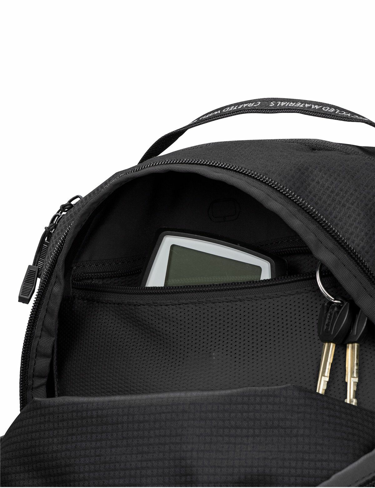 Schwarzer Rucksack, offen, zeigt einen Taschenrechner und Schlüssel in einer Tasche.