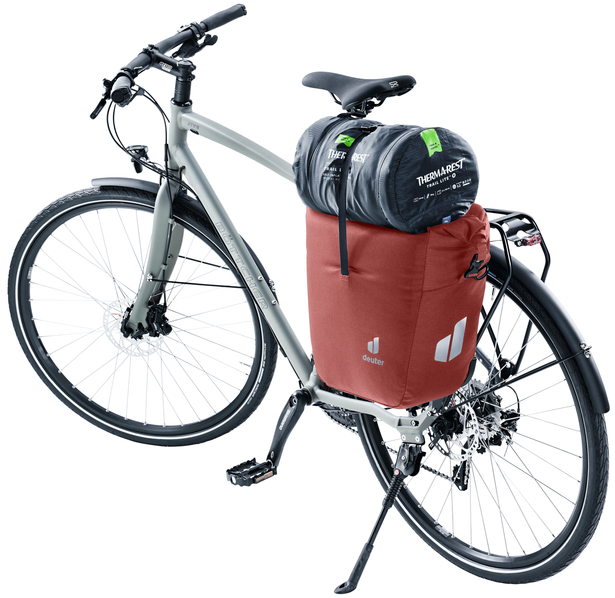 Fahrrad mit roter Packtasche und Schlafsack, vor weißem Hintergrund.