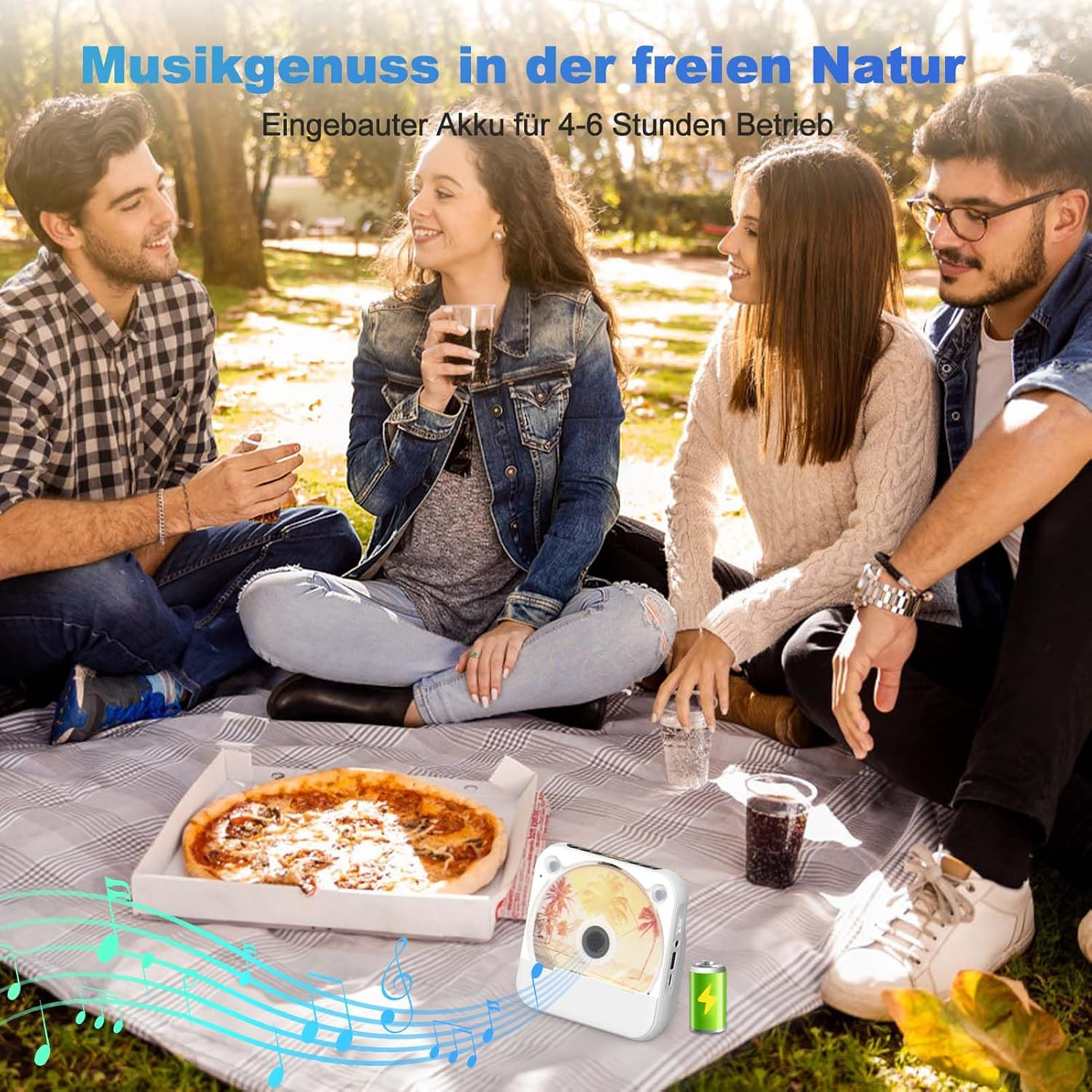 Vier Personen sitzen auf einer Picknickdecke mit Essen und einem Lautsprecher. Sie sind in einem Park.
