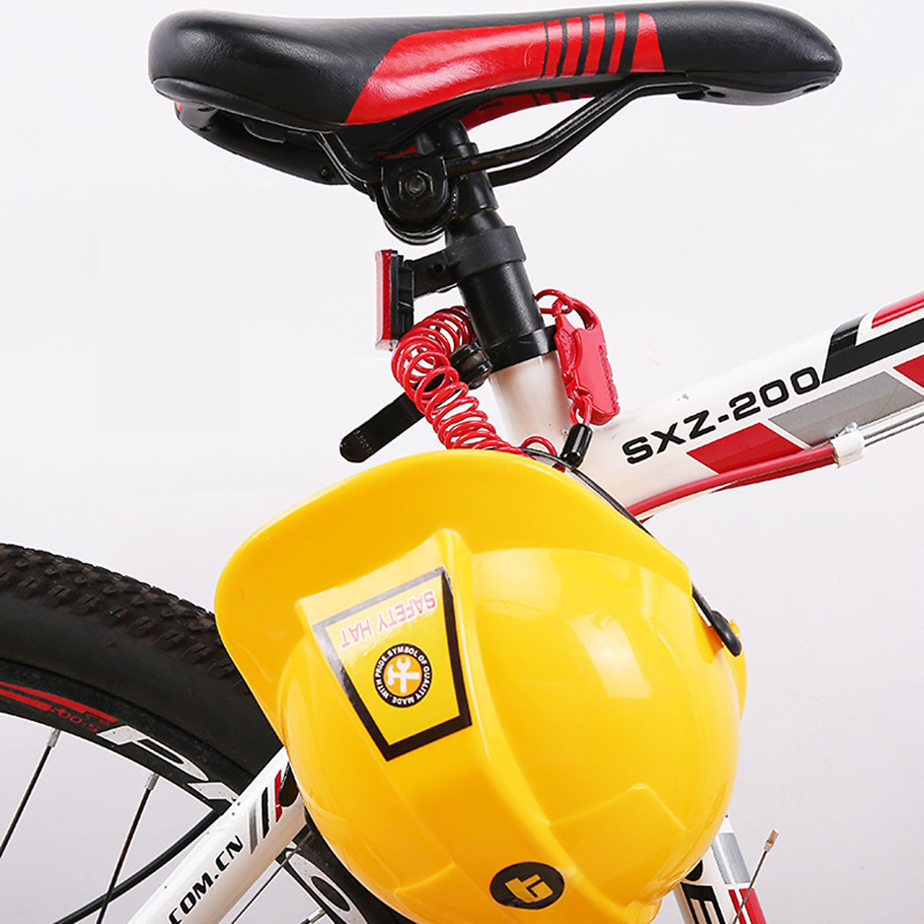 Gelber Schutzhelm an einem Fahrrad. Rotes Spiralschloss am Fahrradrahmen befestigt.