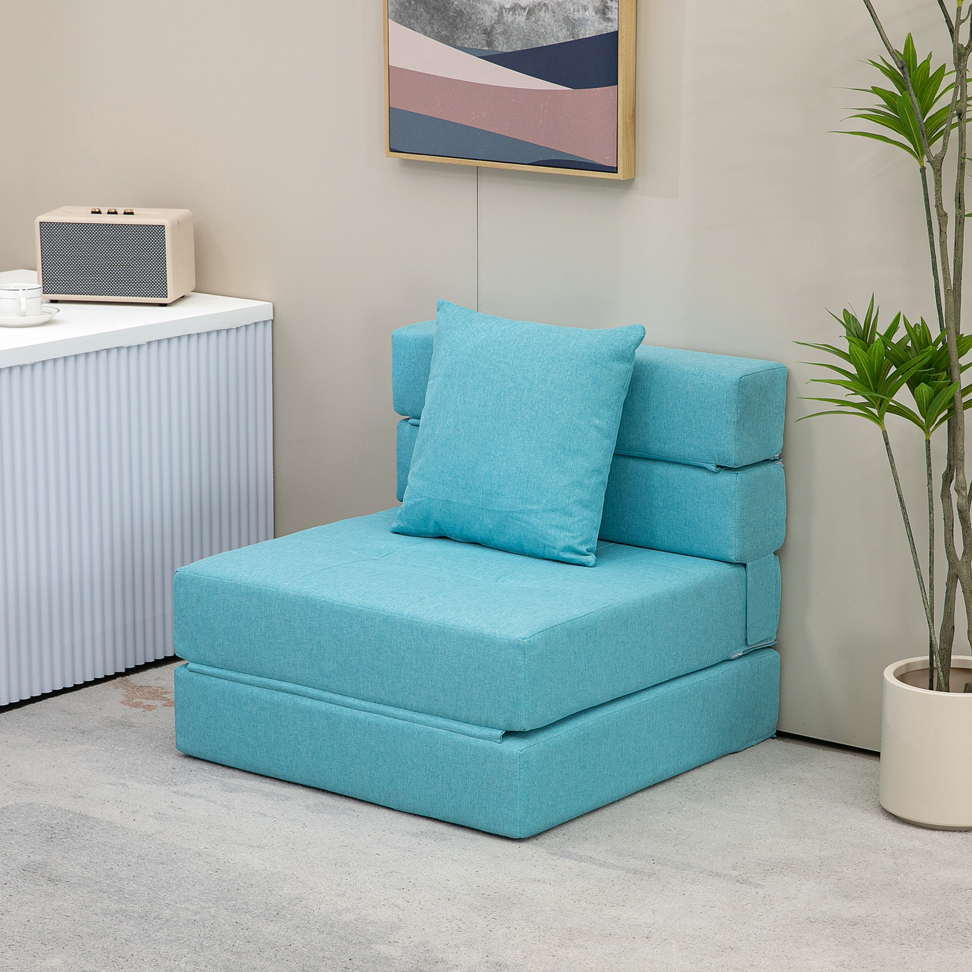 Ein blaues Klappsofa mit hellblauem Kissen, an einer Wand platziert.