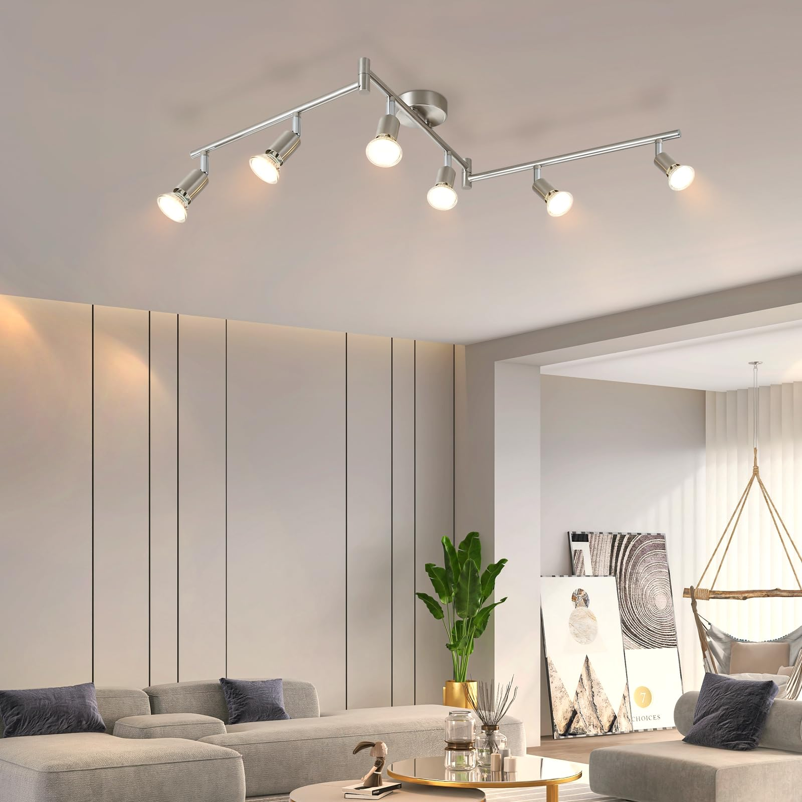 Modernes Wohnzimmer mit Deckenleuchte. Graues Sofa im Vordergrund. Weiße Wände im Hintergrund.