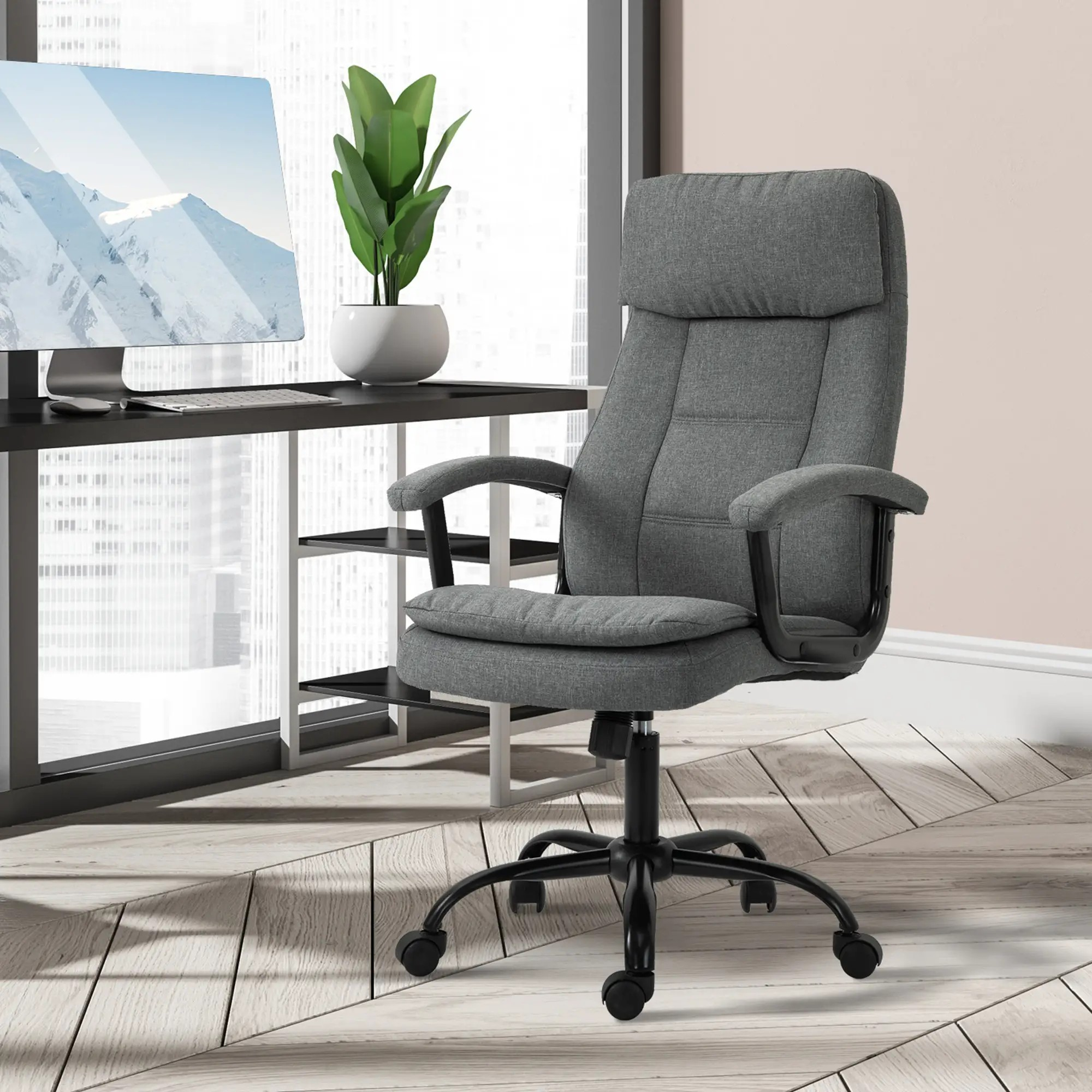 Ein grauer Bürostuhl in einem Homeoffice-Setting, mit Schreibtisch und Pflanze.