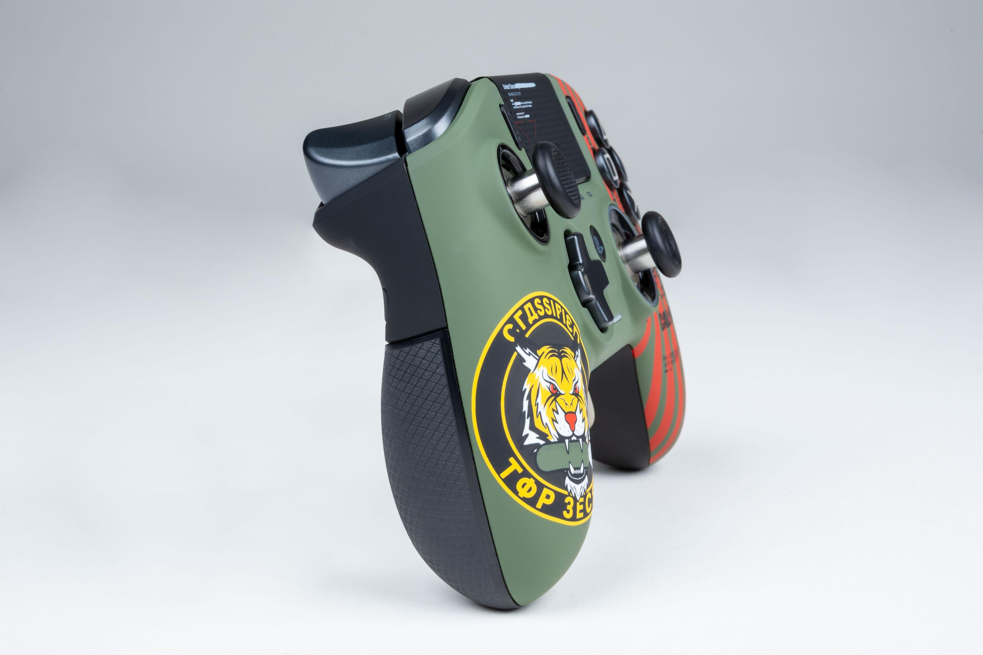 Zielono-czarny gamepad z logo tygrysa i czerwonymi akcentami na białym tle.