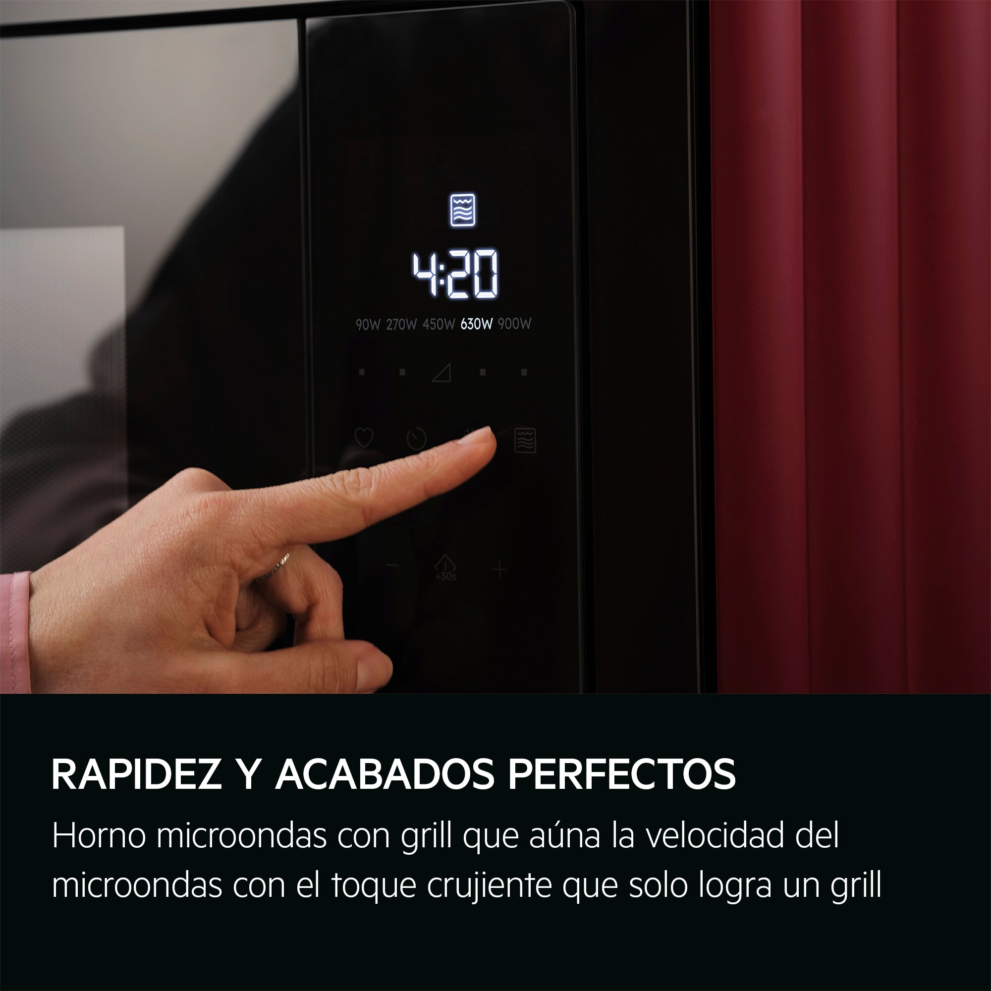 Dłoń naciska przycisk na czarnej kuchence mikrofalowej z cyfrowym wyświetlaczem.