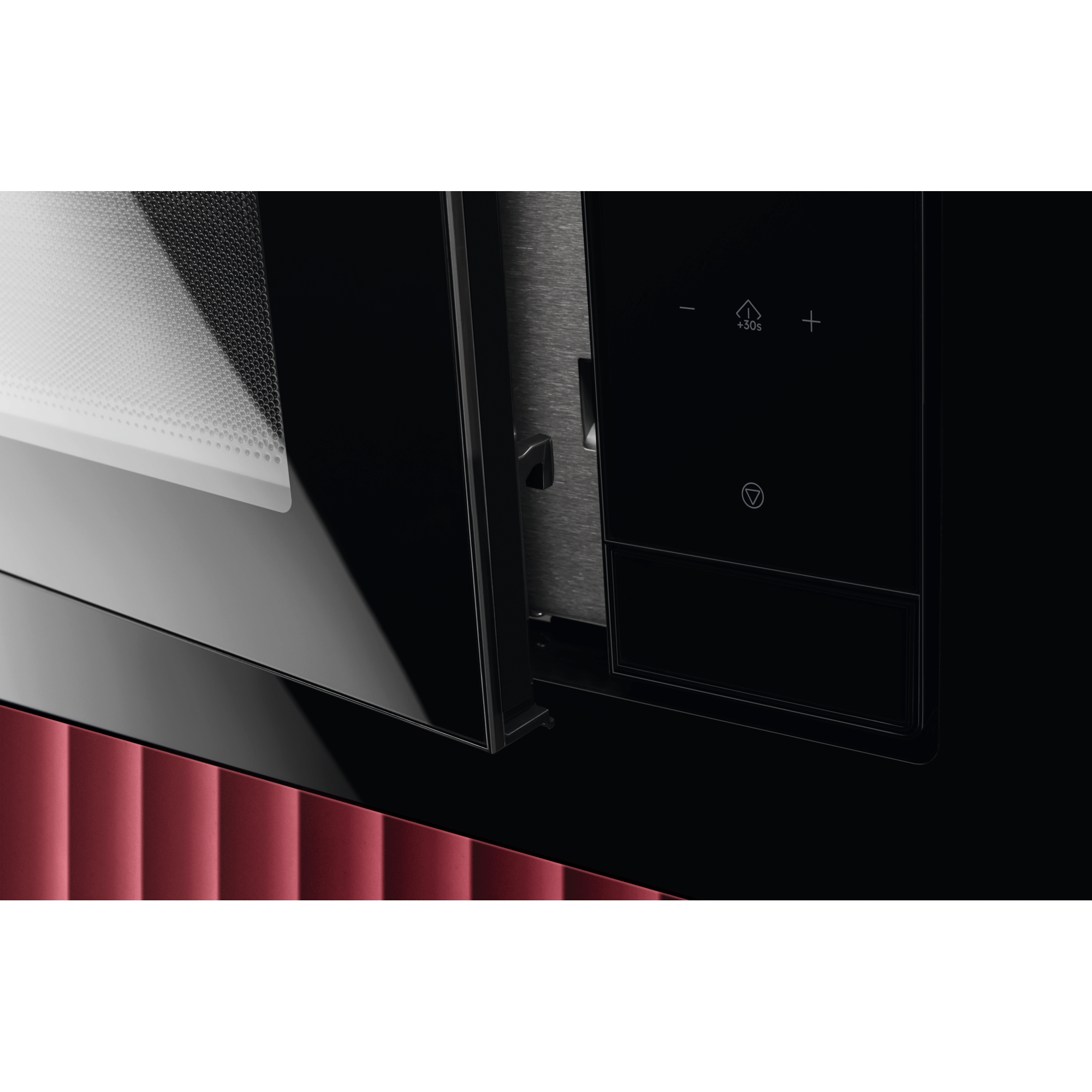 Close-up van een magnetrondeur en bedieningspaneel. De deur is zwart en reflecterend; het paneel heeft knoppen.