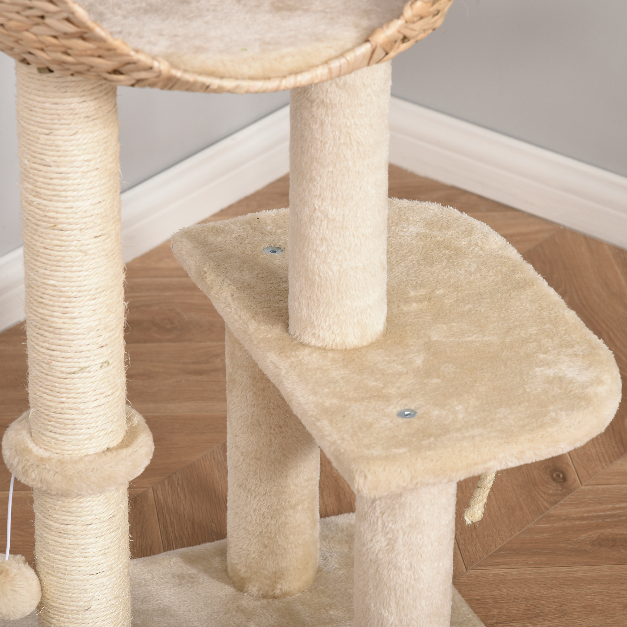 Beiger Katzenbaum mit mehreren Ebenen, Kratzbäumen und einem geflochtenen Korb oben.