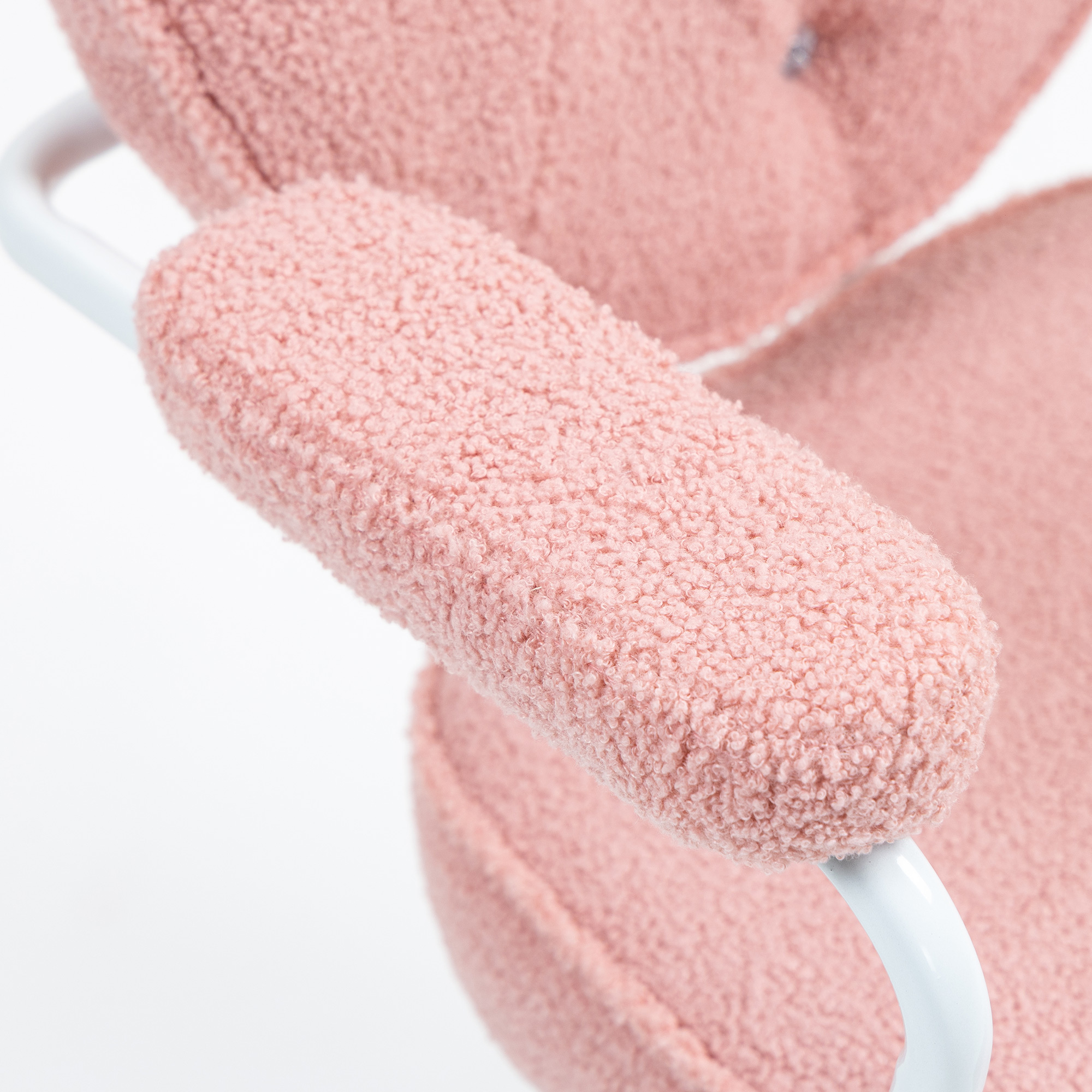 Nahaufnahme einer flauschigen rosa Stuhllehne. Die Lehne ist mit weichem, rosa Fell bedeckt.