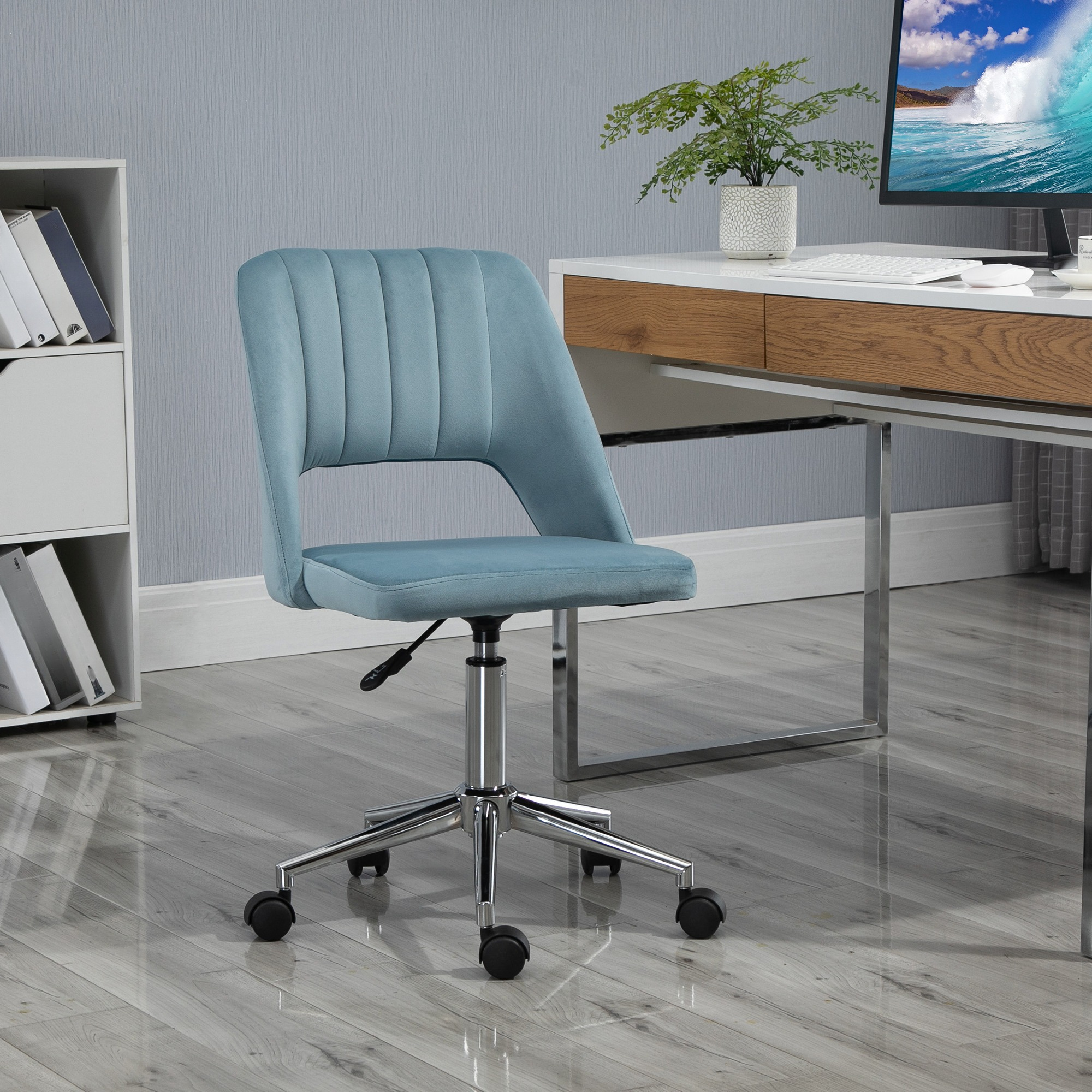Blauer Bürostuhl vor einem Schreibtisch mit Pflanze und Computer. Glänzendes Metallgestell.