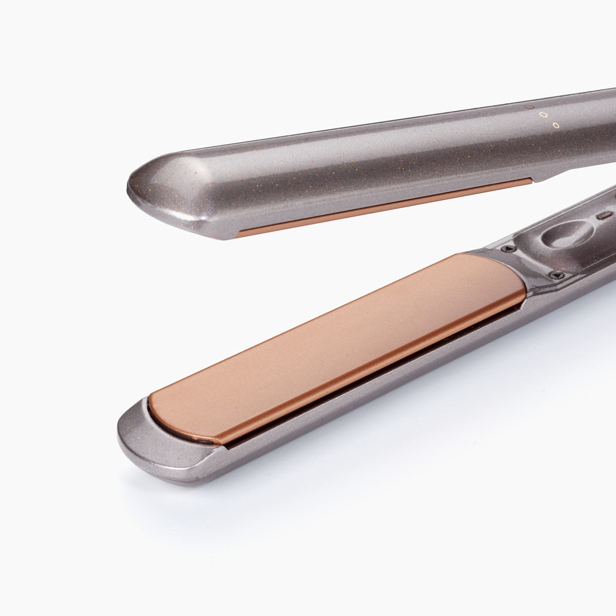 Prostownica do włosów z otwartymi płytkami. Płytki są szare z miedzianymi powierzchniami.