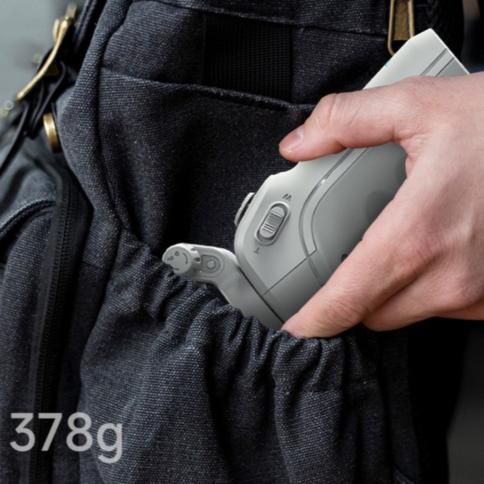 Eine Hand legt ein graues Gerät in die Tasche einer schwarzen Tasche, mit weißem Hintergrund und Text.