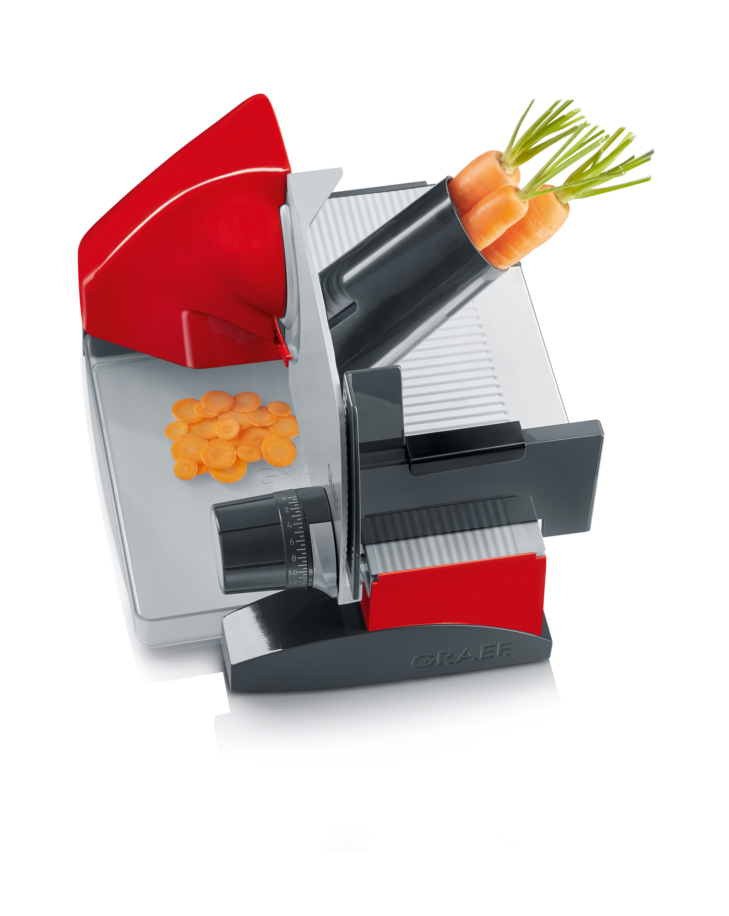 Czerwono-szara krajalnica z marchewką. Pokrojone marchewki są w tacy.