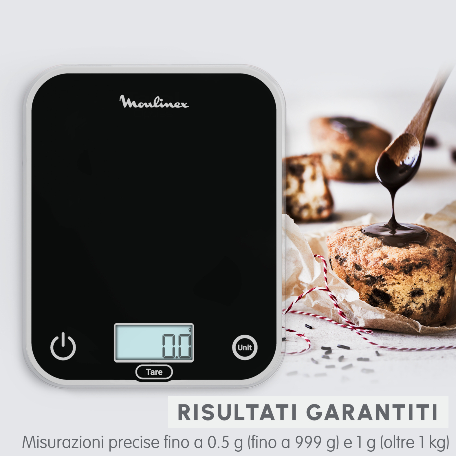 Czarna waga Moulinex z cyfrowym wyświetlaczem pokazującym 0,0. Ciasto jest w tle.
