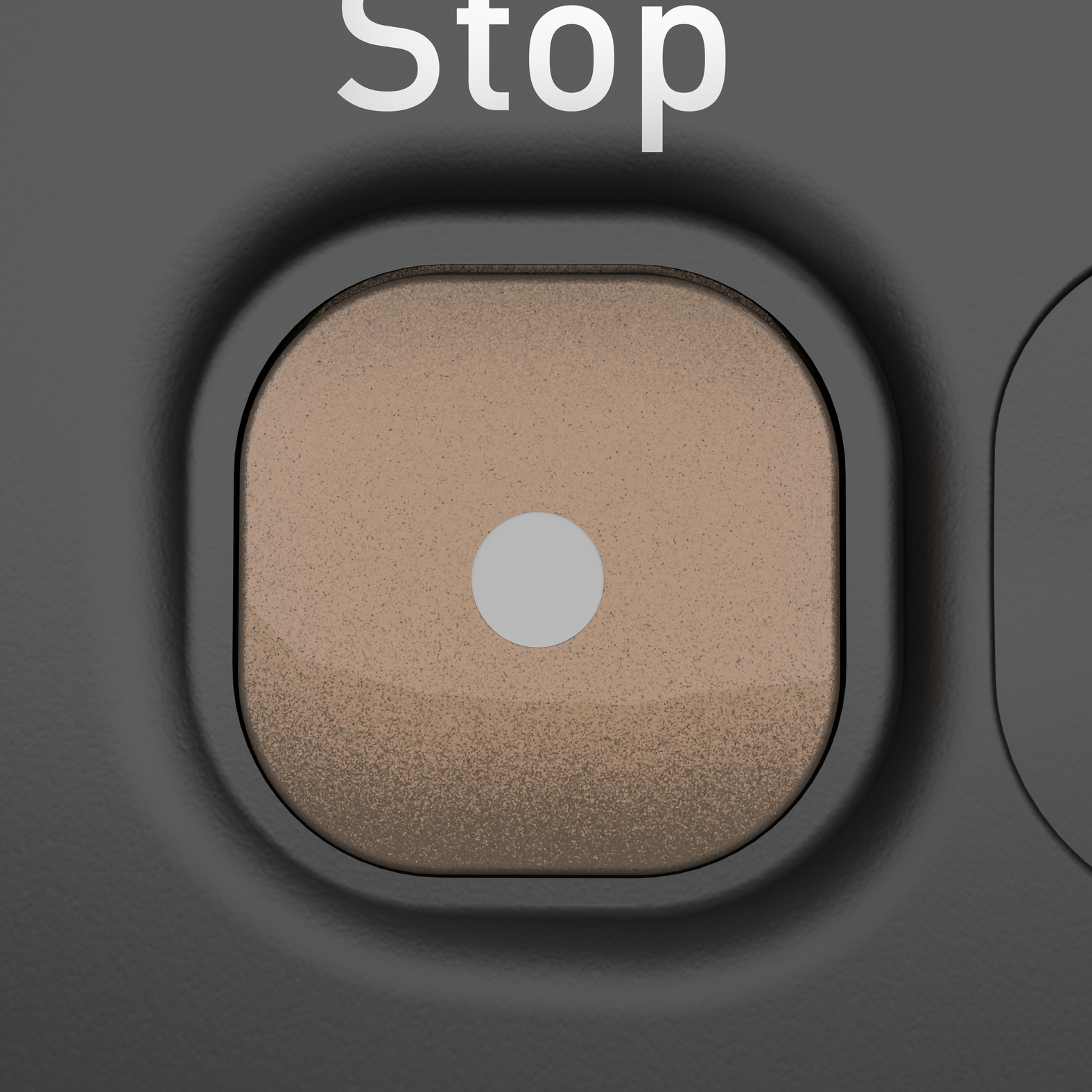 Zbliżenie beżowego przycisku stop na ciemnoszarej powierzchni.