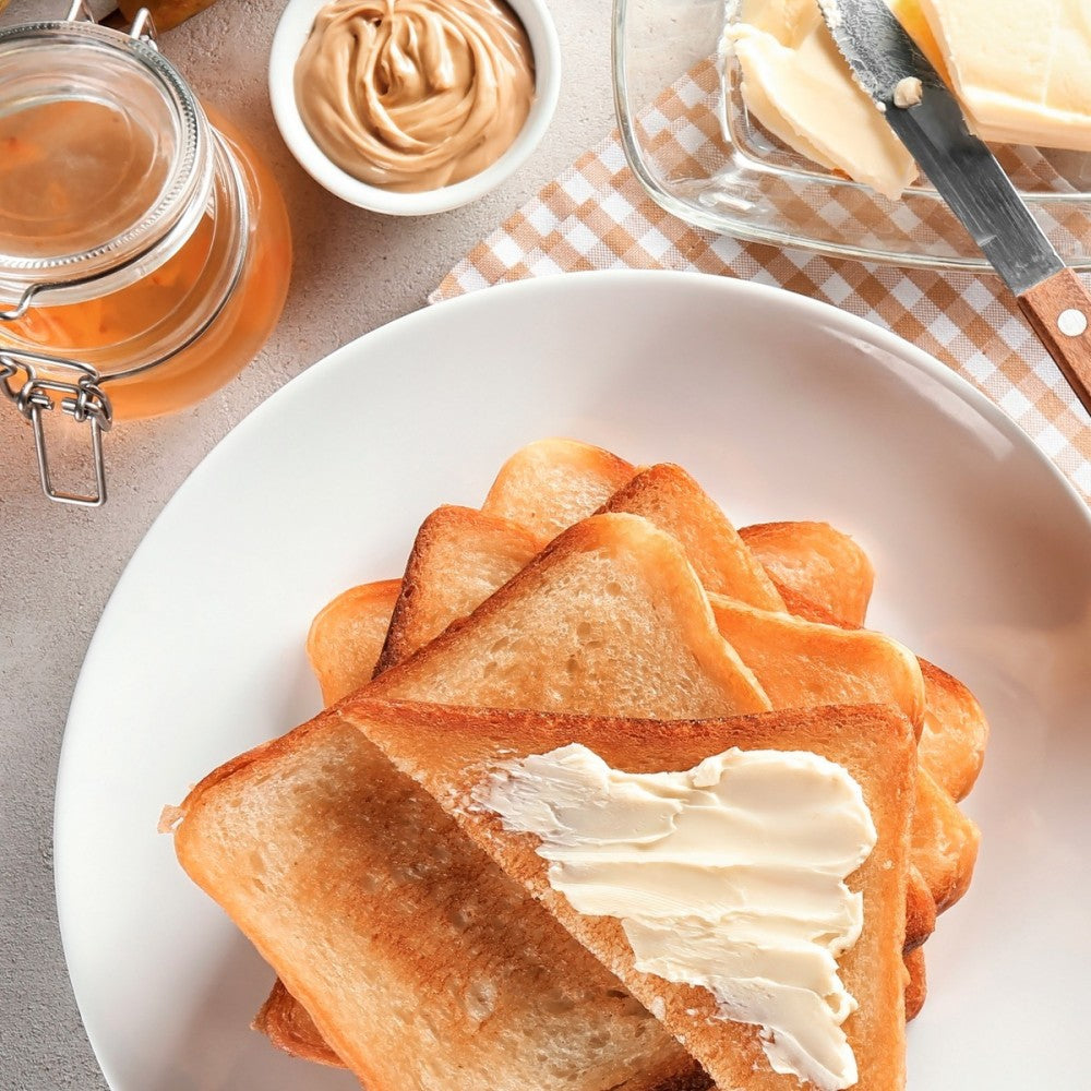 Rebanadas de pan tostado con mantequilla y otros ingredientes como mantequilla de maní y miel.