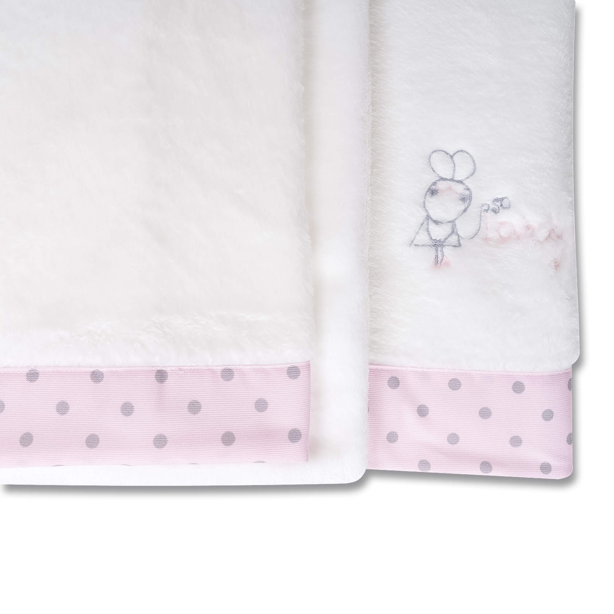 Manta de bebé blanca y rosa con lunares y un dibujo de conejo. Fondo blanco.
